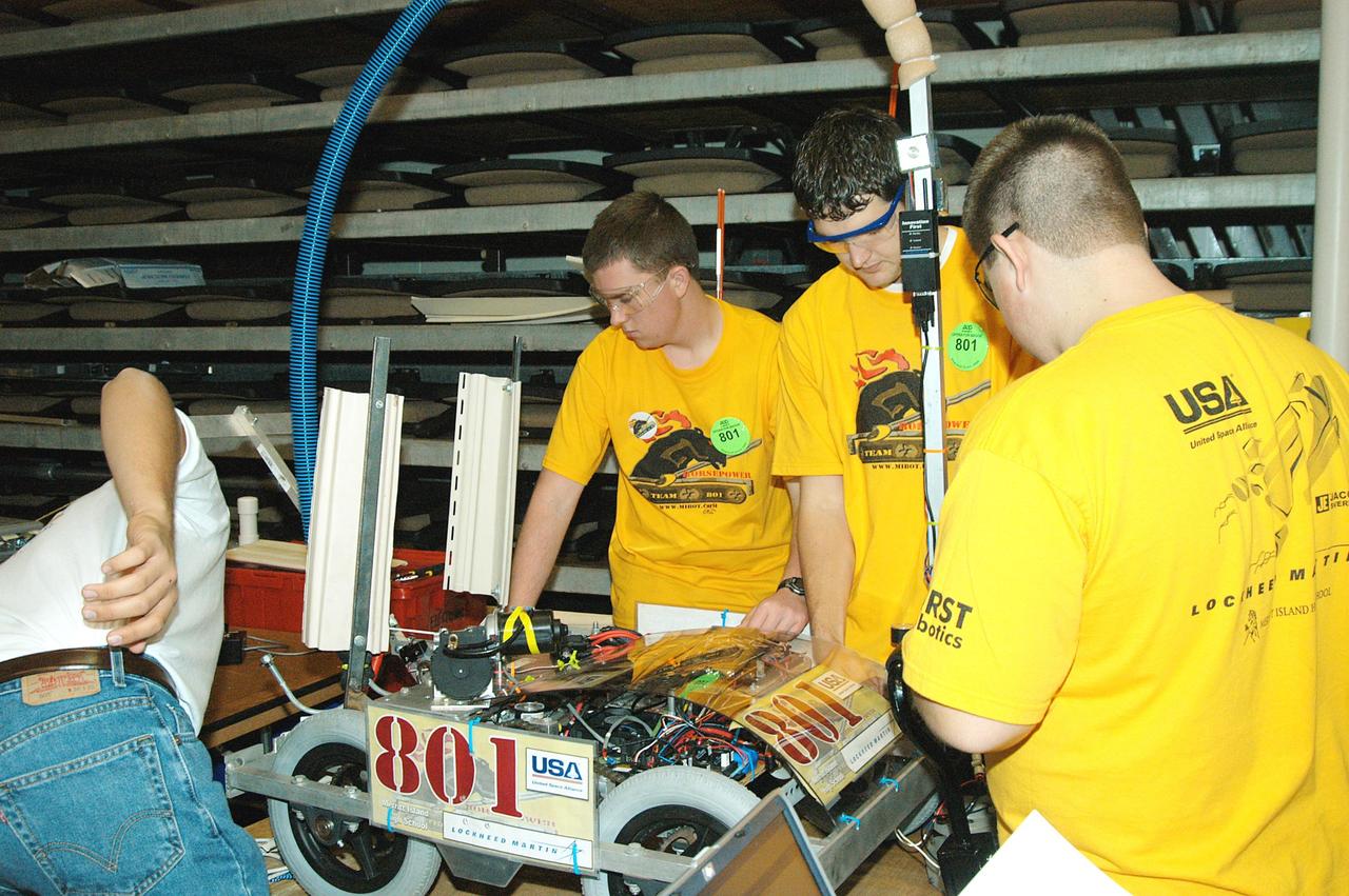 KENNEDY SPACE CENTER, FLA. -  A Lockheed Martin-sponsored student team works on its robot before a match in the 2004 Florida Regional FIRST competition in the University of Central Florida Arena. The event hosted 41 teams from Canada, Brazil, Great Britain and the United States.  Among observers at the annual event were Center Director Jim Kennedy and Florida Gov. Jeb Bush, who spoke at the event luncheon.  FIRST is a nonprofit organization, For Inspiration and Recognition of Science and Technology, that sponsors the event pitting robots against each other in an athletic-style competition. The FIRST robotics competition is designed to provide students with a hands-on, inside look at engineering and other professional careers, pairing high school students with engineer mentors and corporations.