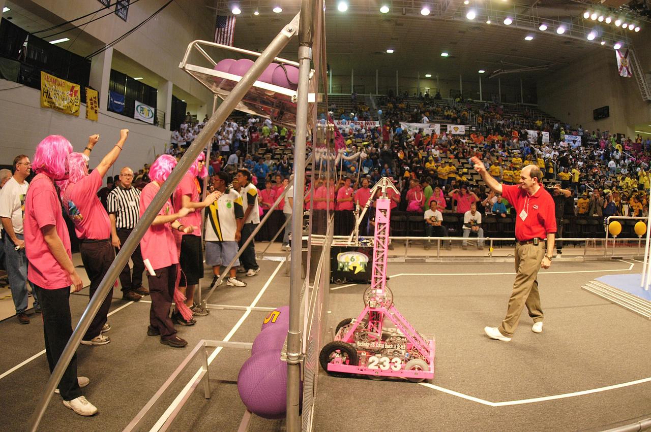 KENNEDY SPACE CENTER, FLA. -  During the 2004 Florida Regional FIRST competition in the University of Central Florida Arena, the KSC-sponsored “Pink” team scores. The event hosted 41 teams from Canada, Brazil, Great Britain and the United States.  Among observers at the annual event were Center Director Jim Kennedy and Florida Gov. Jeb Bush, who spoke at the event luncheon.  FIRST is a nonprofit organization, For Inspiration and Recognition of Science and Technology, that sponsors the event pitting gladiator robots against each other in an athletic-style competition. The FIRST robotics competition is designed to provide students with a hands-on, inside look at engineering and other professional careers, pairing high school students with engineer mentors and corporations.