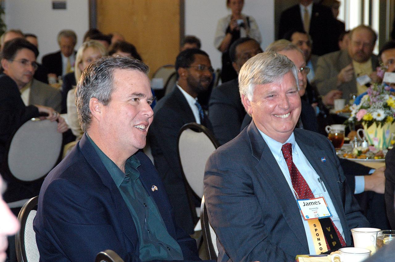 KENNEDY SPACE CENTER, FLA. -  Florida Gov. Jeb Bush (left) and Center Director Jim Kennedy enjoy a humorous break at the luncheon for the 2004 Florida Regional FIRST competition held at the University of Central Florida. Both are featured speakers.  The event hosted 41 teams from Canada, Brazil, Great Britain and the United States.  FIRST is a nonprofit organization, For Inspiration and Recognition of Science and Technology, that sponsors the event pitting gladiator robots against each other in an athletic-style competition. The FIRST robotics competition is designed to provide students with a hands-on, inside look at engineering and other professional careers, pairing high school students with engineer mentors and corporations.