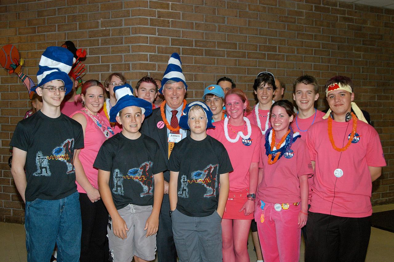 KENNEDY SPACE CENTER, FLA. -  Center Director Jim Kennedy (center) poses for a photo amid the members of the KSC-sponsored “Pink” team and the FIRST LEGO™ League at the 2004 Florida Regional FIRST competition, held at the University of Central Florida.  The annual event is hosting 41 teams from Canada, Brazil, Great Britain and the United States. FIRST is a nonprofit organization, For Inspiration and Recognition of Science and Technology, that sponsors the event pitting gladiator robots against each other in an athletic-style competition. The FIRST robotics competition is designed to provide students with a hands-on, inside look at engineering and other professional careers, pairing high school students with engineer mentors and corporations.