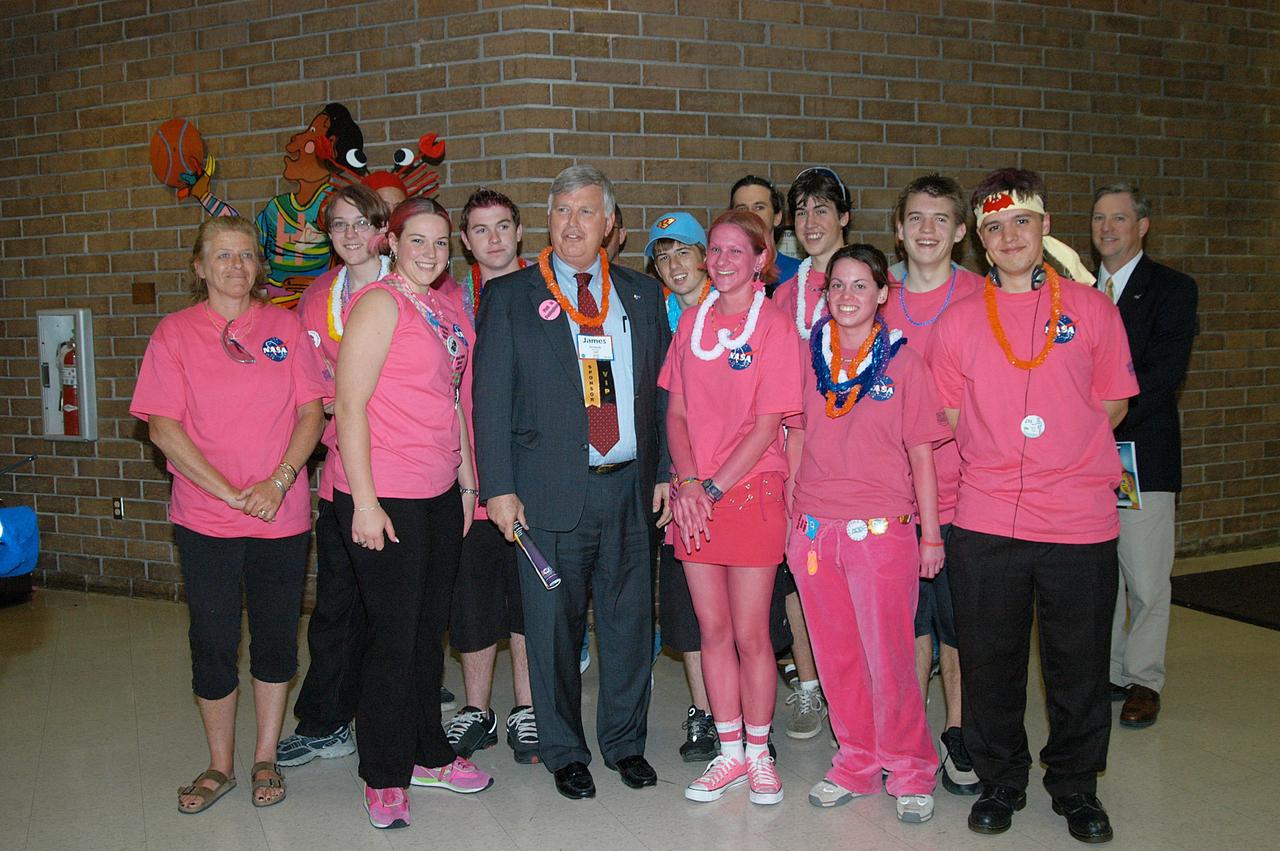 KENNEDY SPACE CENTER, FLA. -  Center Director Jim Kennedy (center) poses for a photo amid the members of the KSC-sponsored “Pink” team at the 2004 Florida Regional FIRST competition, held at the University of Central Florida.  The annual event is hosting 41 teams from Canada, Brazil, Great Britain and the United States. FIRST is a nonprofit organization, For Inspiration and Recognition of Science and Technology, that sponsors the event pitting gladiator robots against each other in an athletic-style competition. The FIRST robotics competition is designed to provide students with a hands-on, inside look at engineering and other professional careers, pairing high school students with engineer mentors and corporations.