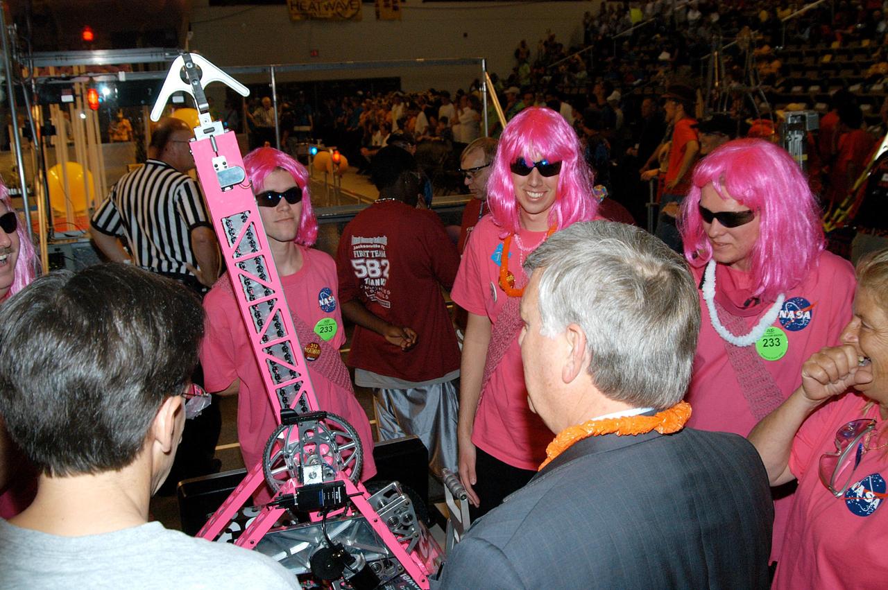 KENNEDY SPACE CENTER, FLA. -  Center Director Jim Kennedy (right, back to camera) talks to members of the KSC-sponsored “Pink” team at the 2004 Florida Regional FIRST competition, held at the University of Central Florida.  The annual event is hosting 41 teams from Canada, Brazil, Great Britain and the United States. FIRST is a nonprofit organization, For Inspiration and Recognition of Science and Technology, that sponsors the event pitting robots against each other in an athletic-style competition. The FIRST robotics competition is designed to provide students with a hands-on, inside look at engineering and other professional careers, pairing high school students with engineer mentors and corporations.