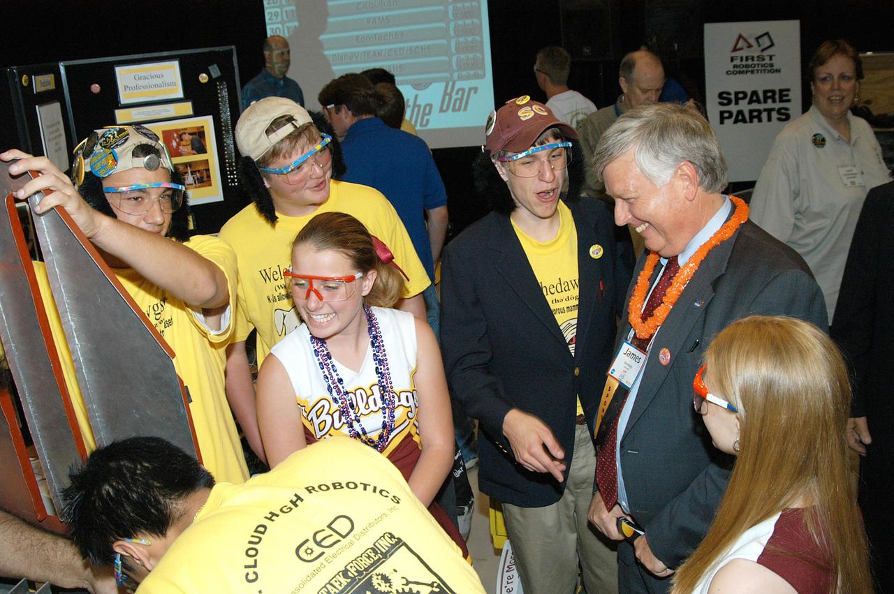 KENNEDY SPACE CENTER, FLA. -  Center Director Jim Kennedy (right) talks to members of one of the teams at the 2004 Florida Regional FIRST competition, held at the University of Central Florida.  The annual event is hosting 41 teams from Canada, Brazil, Great Britain and the United States. FIRST is a nonprofit organization, For Inspiration and Recognition of Science and Technology, that sponsors the event pitting robots against each other in an athletic-style competition. The FIRST robotics competition is designed to provide students with a hands-on, inside look at engineering and other professional careers, pairing high school students with engineer mentors and corporations.