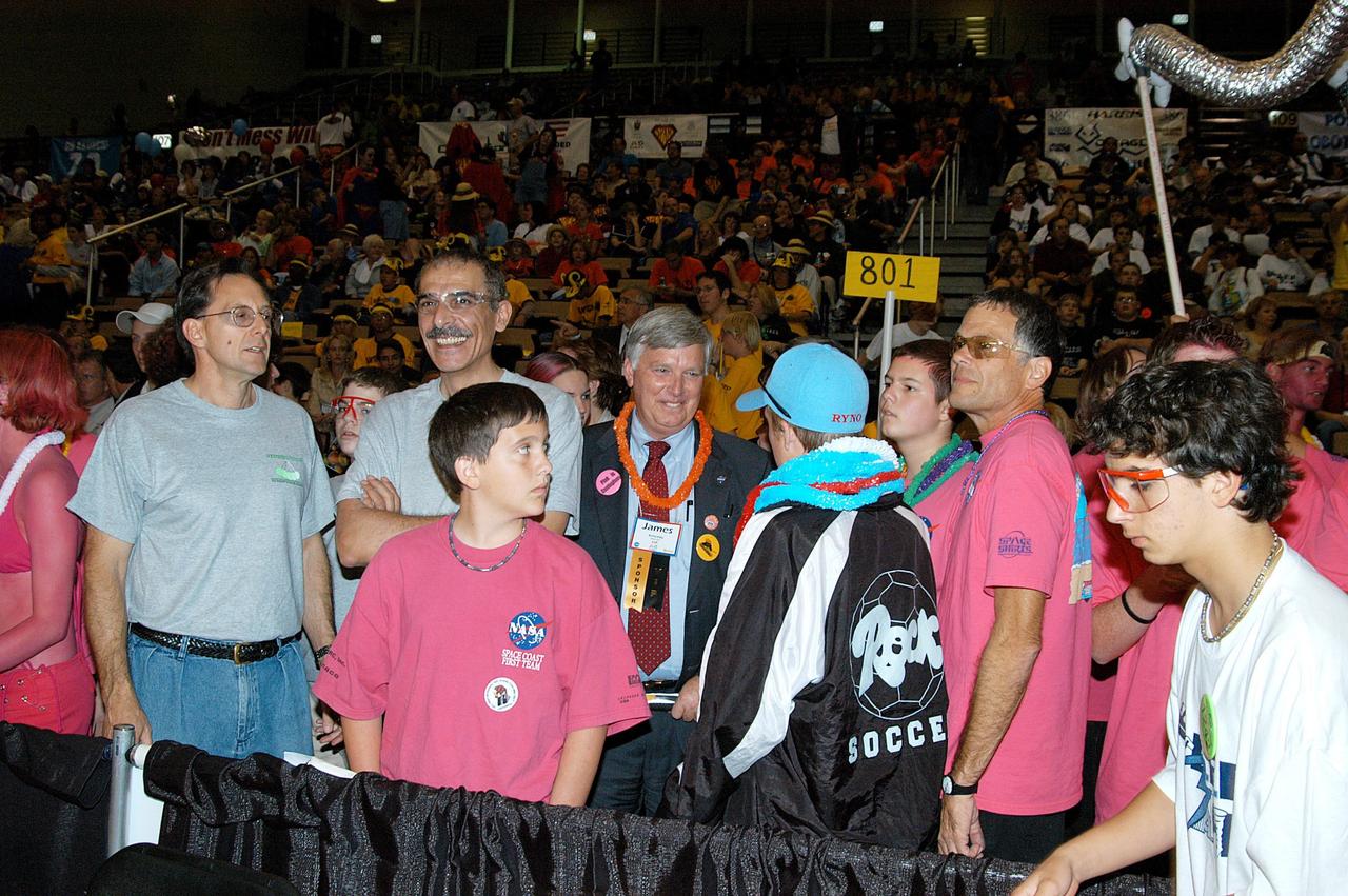 KENNEDY SPACE CENTER, FLA. -  Center Director Jim Kennedy (center) joins team supporters at the 2004 Florida Regional FIRST competition, held at the University of Central Florida.  The annual event is hosting 41 teams from Canada, Brazil, Great Britain and the United States. FIRST is a nonprofit organization, For Inspiration and Recognition of Science and Technology, that sponsors the event pitting robots against each other in an athletic-style competition. The FIRST robotics competition is designed to provide students with a hands-on, inside look at engineering and other professional careers, pairing high school students with engineer mentors and corporations.
