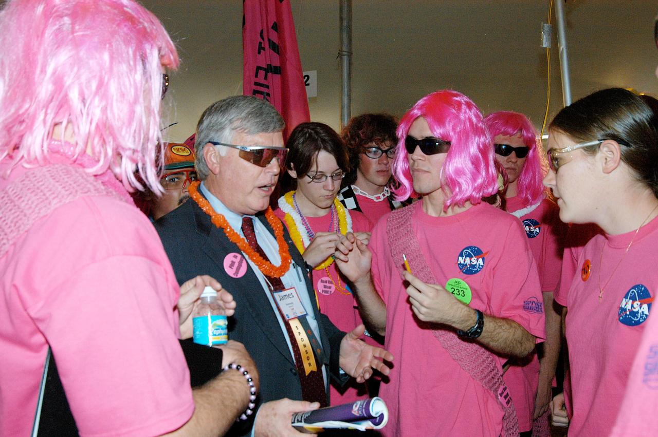 KENNEDY SPACE CENTER, FLA. -  Center Director Jim Kennedy joins students on the KSC-sponsored “Pink” team at the 2004 Florida Regional FIRST competition, held at the University of Central Florida.  The annual event is hosting 41 teams from Canada, Brazil, Great Britain and the United States. FIRST is a nonprofit organization, For Inspiration and Recognition of Science and Technology, that sponsors the event pitting robots against each other in an athletic-style competition. The FIRST robotics competition is designed to provide students with a hands-on, inside look at engineering and other professional careers, pairing high school students with engineer mentors and corporations.