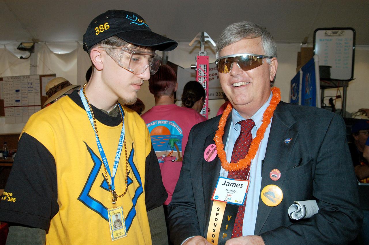 KENNEDY SPACE CENTER, FLA. -  Center Director Jim Kennedy talks with a student team member at the 2004 Florida Regional FIRST competition, held at the University of Central Florida.  The annual event is hosting 41 teams from Canada, Brazil, Great Britain and the United States. FIRST is a nonprofit organization, For Inspiration and Recognition of Science and Technology, that sponsors the event pitting robots against each other in an athletic-style competition. The FIRST robotics competition is designed to provide students with a hands-on, inside look at engineering and other professional careers, pairing high school students with engineer mentors and corporations.