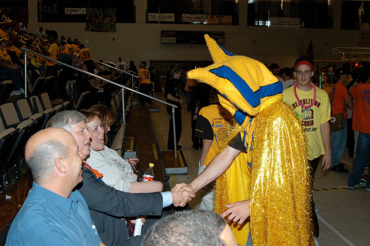 KENNEDY SPACE CENTER, FLA. -  The team mascot of the Central Florida robotic team “Voltage” greets Center Director Jim Kennedy during a match at the 2004 Florida Regional FIRST competition, held at the University of Central Florida.  Among the 41 teams competing from Canada, Brazil, Great Britain and the United States is the KSC-sponsored “Pink” team. FIRST is a nonprofit organization, For Inspiration and Recognition of Science and Technology, that sponsors the event pitting robots against each other in an athletic-style competition. The FIRST robotics competition is designed to provide students with a hands-on, inside look at engineering and other professional careers, pairing high school students with engineer mentors and corporations.