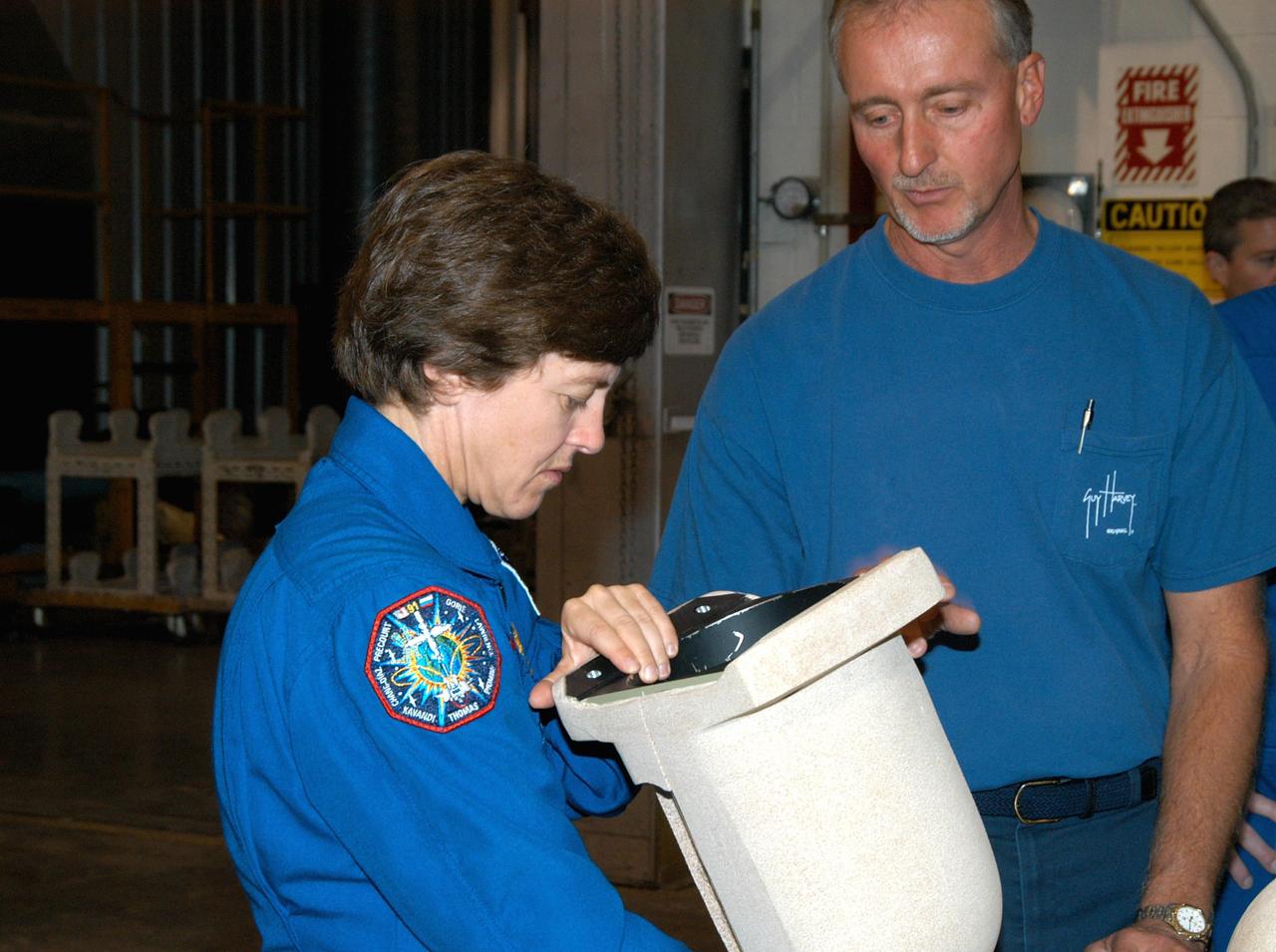 KENNEDY SPACE CENTER, FLA. -  In the SRB Assembly and Refurbishment Facility,  STS-114 Mission Specialist Wendy Lawrence looks at a test design of the bolt catcher insulation.  The STS-114 crew is at KSC for familiarization with Shuttle and mission equipment. The mission is Logistics Flight 1, which is scheduled to deliver supplies and equipment, plus the external stowage platform, to the International Space Station.