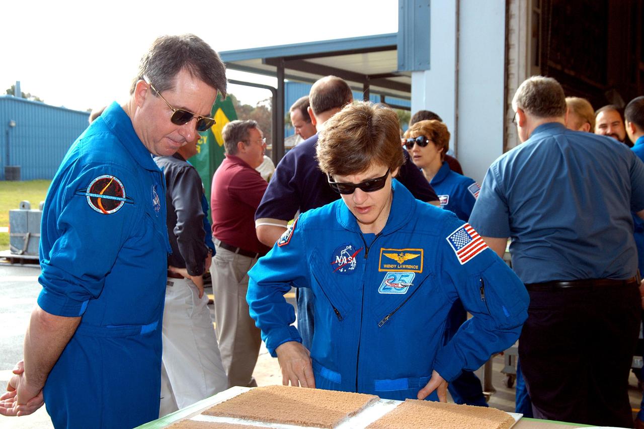 KENNEDY SPACE CENTER, FLA. -  At the SRB Assembly and Refurbishment Facility, STS-114 Mission Specialists Stephen Robinson and Wendy Lawrence look at a test panel of insulation material cut in a liquid nitrogen process.   The STS-114 crew is at KSC for familiarization with Shuttle and mission equipment. The mission is Logistics Flight 1, which is scheduled to deliver supplies and equipment, plus the external stowage platform, to the International Space Station.