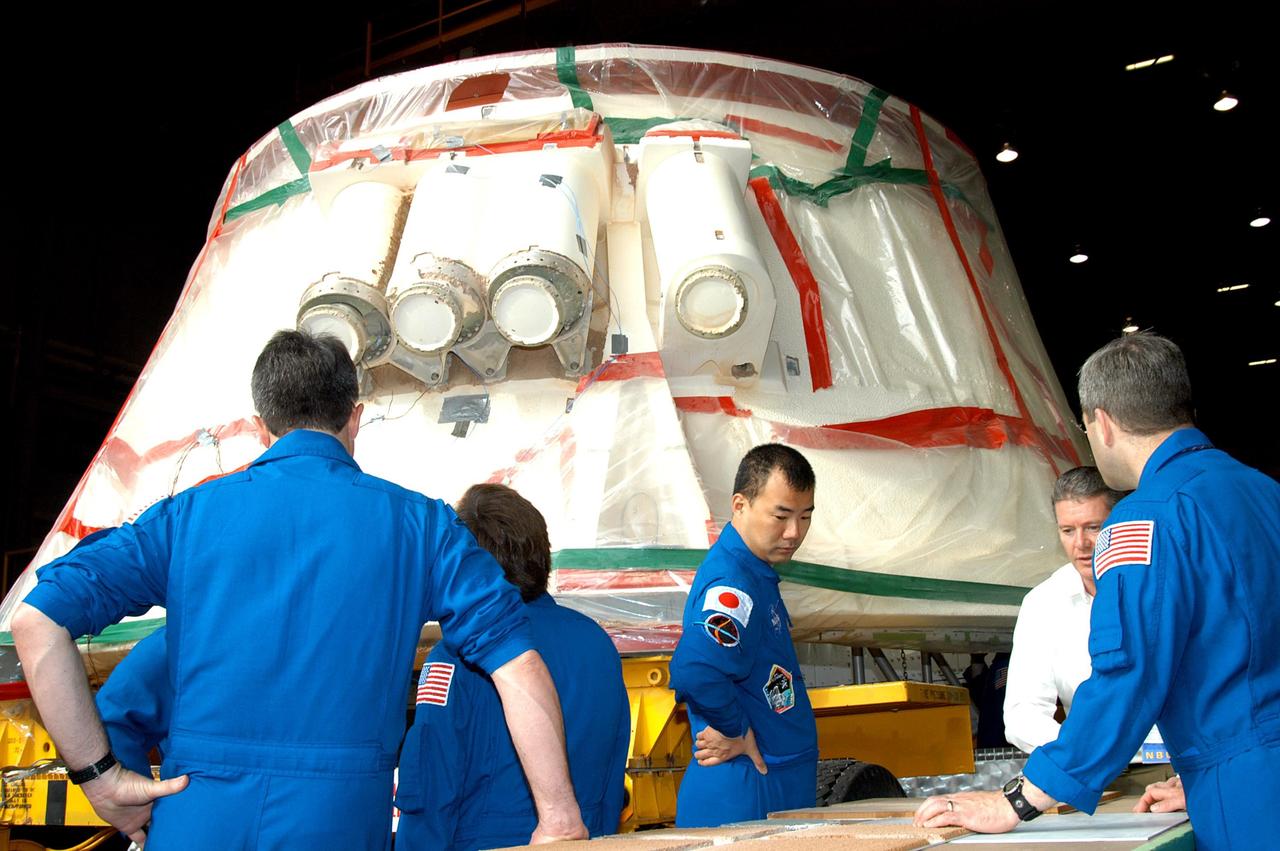 KENNEDY SPACE CENTER, FLA. - At the SRB Assembly and Refurbishment Facility, STS-114 crew members look at the booster separation motors (BSM) on a solid rocket booster aft skirt. The BSMs have had booster trowlable ablative removed by liquid nitrogen cutting. The STS-114 crew is at KSC for familiarization with Shuttle and mission equipment. The mission is Logistics Flight 1, which is scheduled to deliver supplies and equipment, plus the external stowage platform, to the International Space Station.