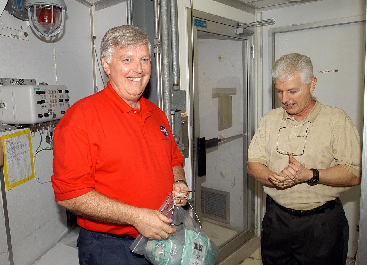 KENNEDY SPACE CENTER, FLA. -  Center Director Jim Kennedy (left) takes an opportunity to learn first-hand what workers are doing to enable Return to Flight.  Here he prepares to don a bunny suit in the Orbiter Processing Facility before entering the orbiter Endeavour, which is in an Orbiter Major Modification period.