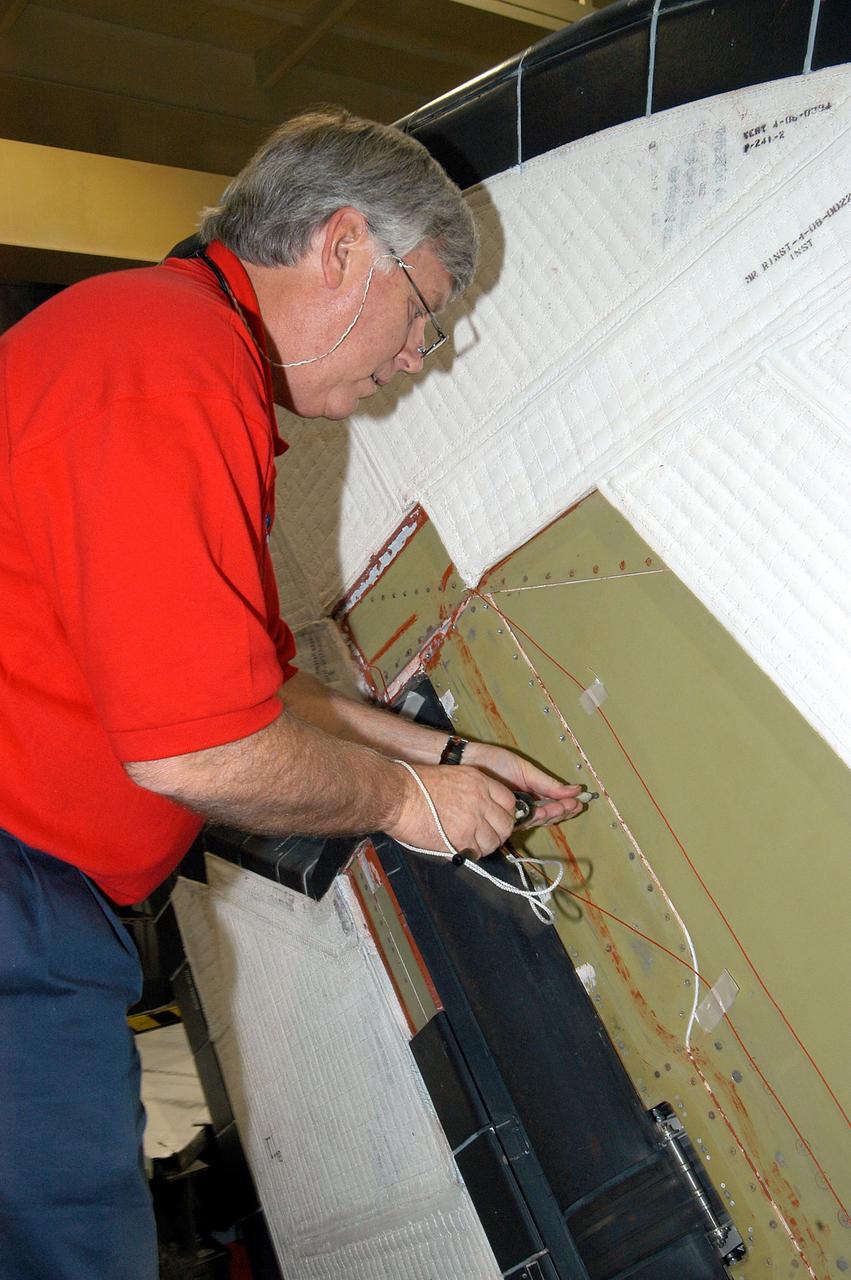 KENNEDY SPACE CENTER, FLA. -  In the Orbiter Processing Facility, Center Director Jim Kennedy takes a turn on a screw on Endeavour.  Kennedy is taking an opportunity to learn first-hand what workers are doing to enable Return to Flight.  Endeavour is in an Orbiter Major Modification period.