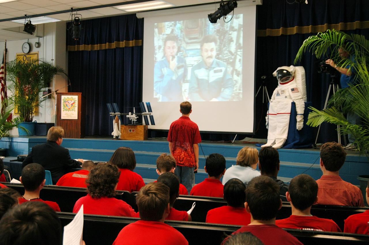 KENNEDY SPACE CENTER, FLA. - At Howard Bishop Middle School in Gainesville, Fla., a student asks the Expedition 8 crew (Commander Michael Foale and Flight Engineer Alexander Kaleri seen on the screen on stage) a question in a downlink from the International Space Station. During a presentation that shared the new vision for space exploration, KSC Deputy Director Dr. Woodrow Whitlow Jr. talked about our destiny as explorers, NASA’s stepping stone approach to exploring Earth, the Moon, Mars and beyond, how space impacts our lives, and how people and machines rely on each other in space. Howard Bishop Middle School is one of 50 nationwide (four in Florida) in the NASA Explorer Schools (NES) Program. NES establishes a three-year partnership between NASA and 50 NASA Explorer Schools teams, consisting of teachers and education administrators from diverse communities nationwide.