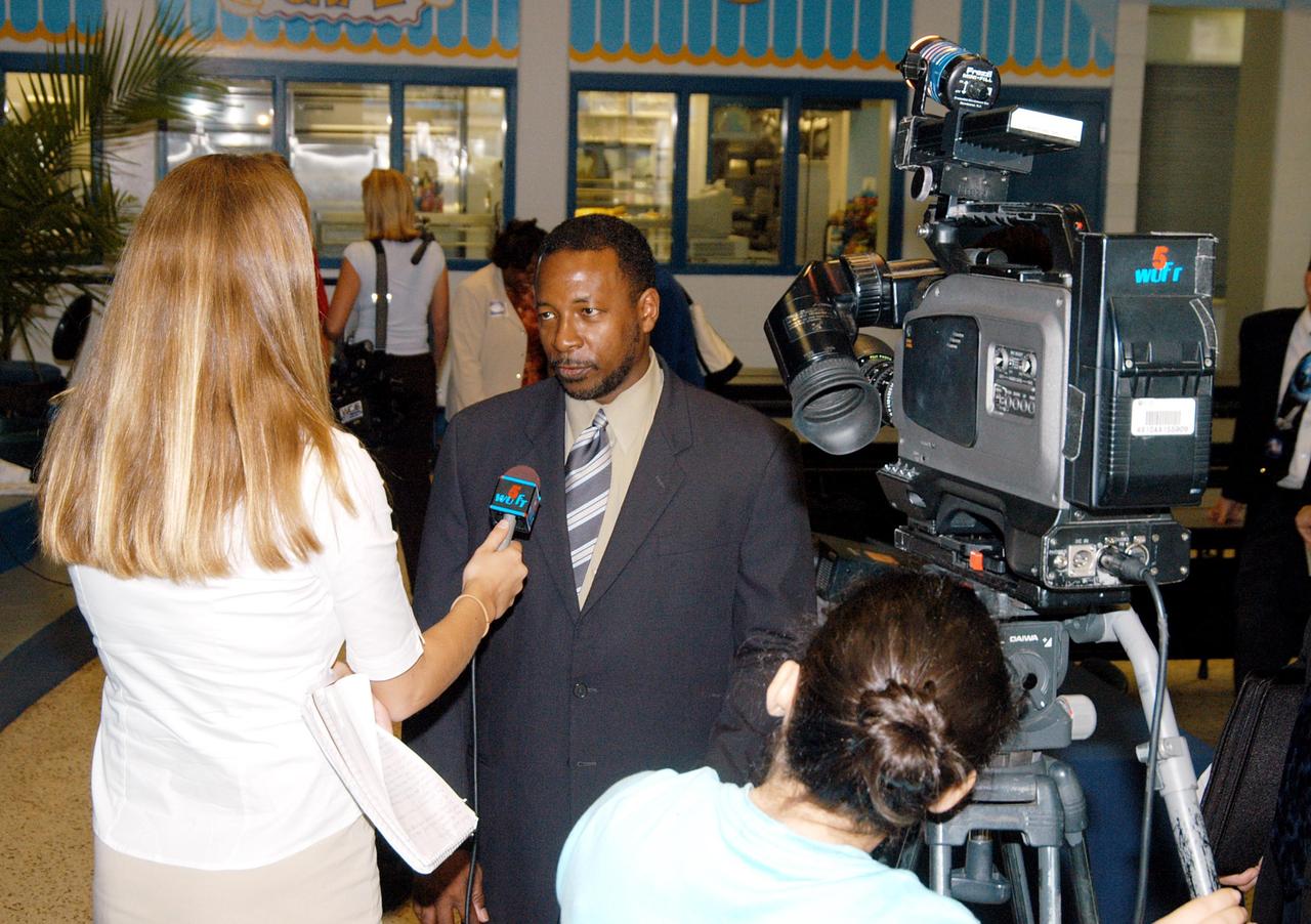 KENNEDY SPACE CENTER, FLA. - KSC Deputy Director Woodrow Whitlow Jr. (center) is interviewed by TV station WUFT after a presentation at Howard Bishop Middle School in Gainesville, Fla. Dr. Whitlow shared the new vision for space exploration with the students, the next generation of explorers. Whitlow talked about our destiny as explorers, NASA’s stepping stone approach to exploring Earth, the Moon, Mars and beyond, how space impacts our lives, and how people and machines rely on each other in space. The presentation also included a downlink from the International Space Station for students to ask questions of the Expedition 8 crew, Commander Michael Foale and Flight Engineer Alexander Kaleri. Howard Bishop Middle School is one of 50 nationwide (four in Florida) in the NASA Explorer Schools (NES) Program. NES establishes a three-year partnership between NASA and 50 NASA Explorer Schools teams, consisting of teachers and education administrators from diverse communities nationwide