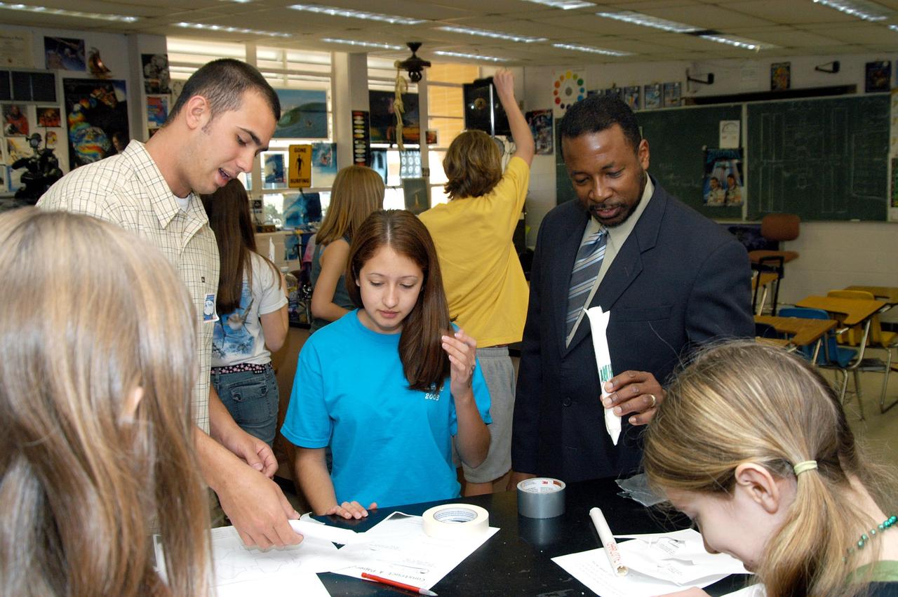 KENNEDY SPACE CENTER, FLA. - KSC Deputy Director Woodrow Whitlow Jr. looks at students’ projects in a classroom at Howard Bishop Middle School in Gainesville, Fla. Dr. Whitlow shared the new vision for space exploration with the students, the next generation of explorers. Whitlow talked about our destiny as explorers, NASA’s stepping stone approach to exploring Earth, the Moon, Mars and beyond, how space impacts our lives, and how people and machines rely on each other in space. The presentation also included a downlink from the International Space Station for students to ask questions of the Expedition 8 crew, Commander Michael Foale and Flight Engineer Alexander Kaleri. Howard Bishop Middle School is one of 50 nationwide (four in Florida) in the NASA Explorer Schools (NES) Program. NES establishes a three-year partnership between NASA and 50 NASA Explorer Schools teams, consisting of teachers and education administrators from diverse communities nationwide.