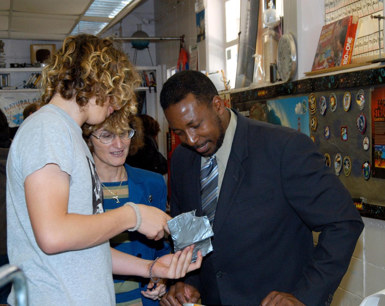 KENNEDY SPACE CENTER, FLA. - KSC Deputy Director Woodrow Whitlow Jr. talks to a student about his project in a classroom at Howard Bishop Middle School in Gainesville, Fla. Dr. Whitlow shared the new vision for space exploration with the students, the next generation of explorers. Whitlow talked about our destiny as explorers, NASA’s stepping stone approach to exploring Earth, the Moon, Mars and beyond, how space impacts our lives, and how people and machines rely on each other in space. The presentation also included a downlink from the International Space Station for students to ask questions of the Expedition 8 crew, Commander Michael Foale and Flight Engineer Alexander Kaleri. Howard Bishop Middle School is one of 50 nationwide (four in Florida) in the NASA Explorer Schools (NES) Program. NES establishes a three-year partnership between NASA and 50 NASA Explorer Schools teams, consisting of teachers and education administrators from diverse communities nationwide.