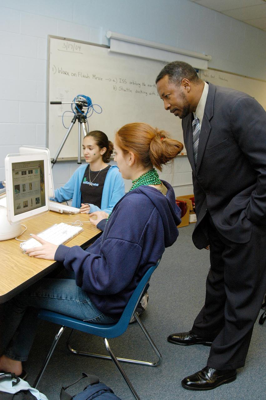 KENNEDY SPACE CENTER, FLA. - KSC Deputy Director Woodrow Whitlow Jr. looks at a student’s computer project after his presentation in the classroom at Howard Bishop Middle School in Gainesville, Fla. Dr. Whitlow shared the new vision for space exploration with the students, the next generation of explorers. Whitlow talked about our destiny as explorers, NASA’s stepping stone approach to exploring Earth, the Moon, Mars and beyond, how space impacts our lives, and how people and machines rely on each other in space. The presentation also included a downlink from the International Space Station for students to ask questions of the Expedition 8 crew, Commander Michael Foale and Flight Engineer Alexander Kaleri. Howard Bishop Middle School is one of 50 nationwide (four in Florida) in the NASA Explorer Schools (NES) Program. NES establishes a three-year partnership between NASA and 50 NASA Explorer Schools teams, consisting of teachers and education administrators from diverse communities nationwide.