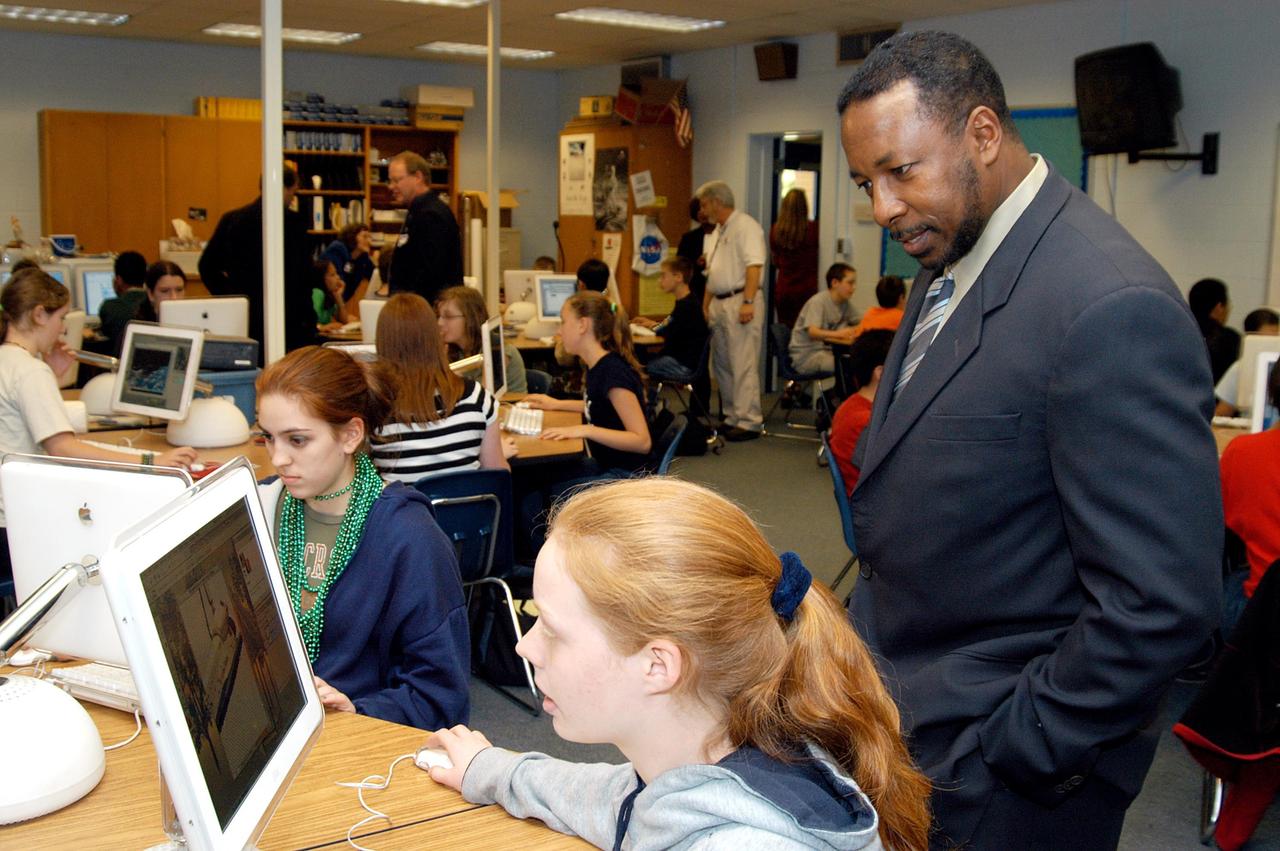KENNEDY SPACE CENTER, FLA. - KSC Deputy Director Woodrow Whitlow Jr. looks at a student’s computer project after his presentation in the classroom at Howard Bishop Middle School in Gainesville, Fla. Dr. Whitlow shared the new vision for space exploration with the students, the next generation of explorers. Whitlow talked about our destiny as explorers, NASA’s stepping stone approach to exploring Earth, the Moon, Mars and beyond, how space impacts our lives, and how people and machines rely on each other in space. The presentation also included a downlink from the International Space Station for students to ask questions of the Expedition 8 crew, Commander Michael Foale and Flight Engineer Alexander Kaleri. Howard Bishop Middle School is one of 50 nationwide (four in Florida) in the NASA Explorer Schools (NES) Program. NES establishes a three-year partnership between NASA and 50 NASA Explorer Schools teams, consisting of teachers and education administrators from diverse communities nationwide.