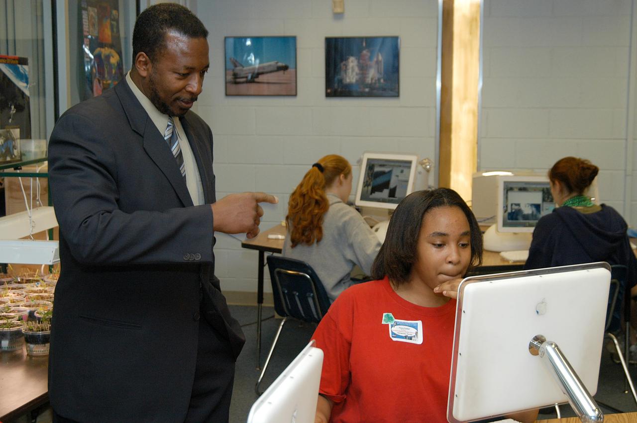 KENNEDY SPACE CENTER, FLA. - KSC Deputy Director Woodrow Whitlow Jr. looks at a student’s computer project after his presentation in the classroom at Howard Bishop Middle School in Gainesville, Fla. Dr. Whitlow shared the new vision for space exploration with the students, the next generation of explorers. Whitlow talked about our destiny as explorers, NASA’s stepping stone approach to exploring Earth, the Moon, Mars and beyond, how space impacts our lives, and how people and machines rely on each other in space. The presentation also included a downlink from the International Space Station for students to ask questions of the Expedition 8 crew, Commander Michael Foale and Flight Engineer Alexander Kaleri. Howard Bishop Middle School is one of 50 nationwide (four in Florida) in the NASA Explorer Schools (NES) Program. NES establishes a three-year partnership between NASA and 50 NASA Explorer Schools teams, consisting of teachers and education administrators from diverse communities nationwide.