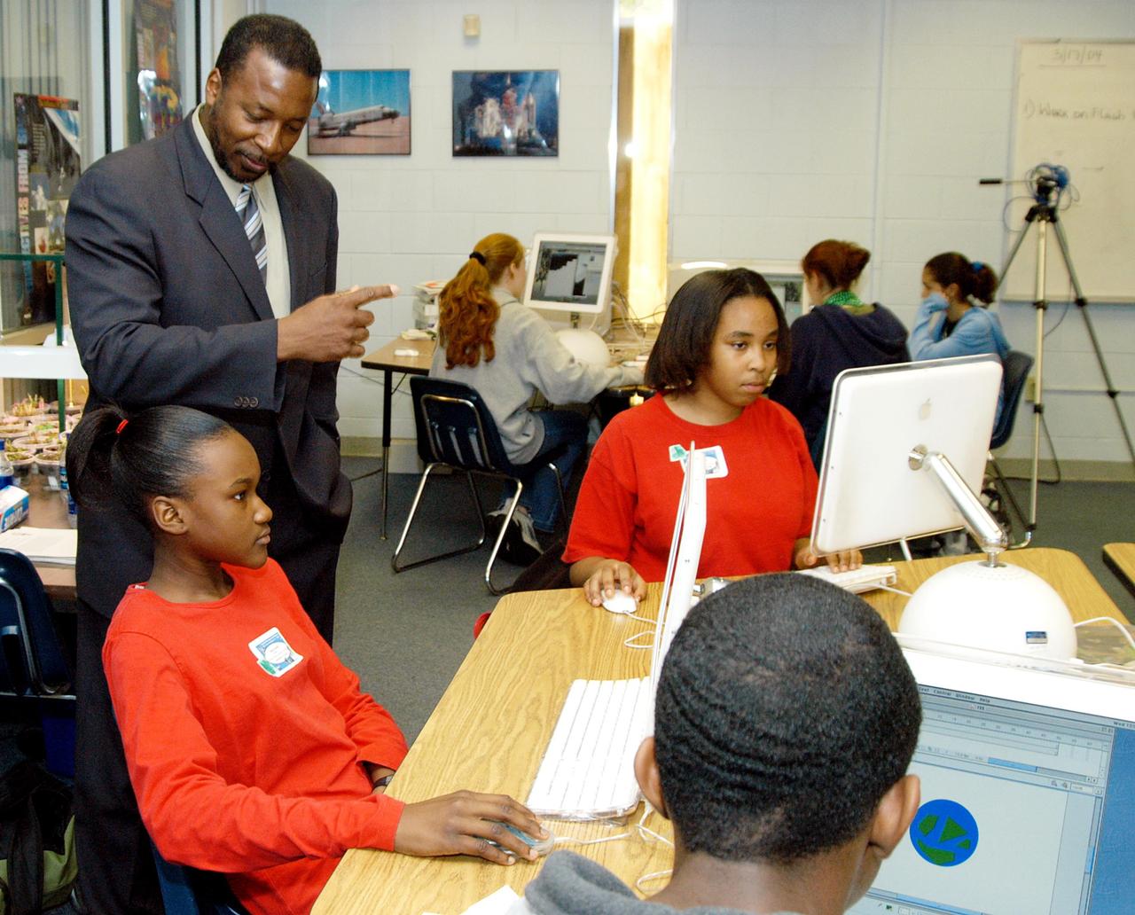 KENNEDY SPACE CENTER, FLA. - KSC Deputy Director Woodrow Whitlow Jr. looks at a student’s computer project after his presentation in the classroom at Howard Bishop Middle School in Gainesville, Fla. Dr. Whitlow shared the new vision for space exploration with the students, the next generation of explorers. Whitlow talked about our destiny as explorers, NASA’s stepping stone approach to exploring Earth, the Moon, Mars and beyond, how space impacts our lives, and how people and machines rely on each other in space. The presentation also included a downlink from the International Space Station for students to ask questions of the Expedition 8 crew, Commander Michael Foale and Flight Engineer Alexander Kaleri. Howard Bishop Middle School is one of 50 nationwide (four in Florida) in the NASA Explorer Schools (NES) Program. NES establishes a three-year partnership between NASA and 50 NASA Explorer Schools teams, consisting of teachers and education administrators from diverse communities nationwide.