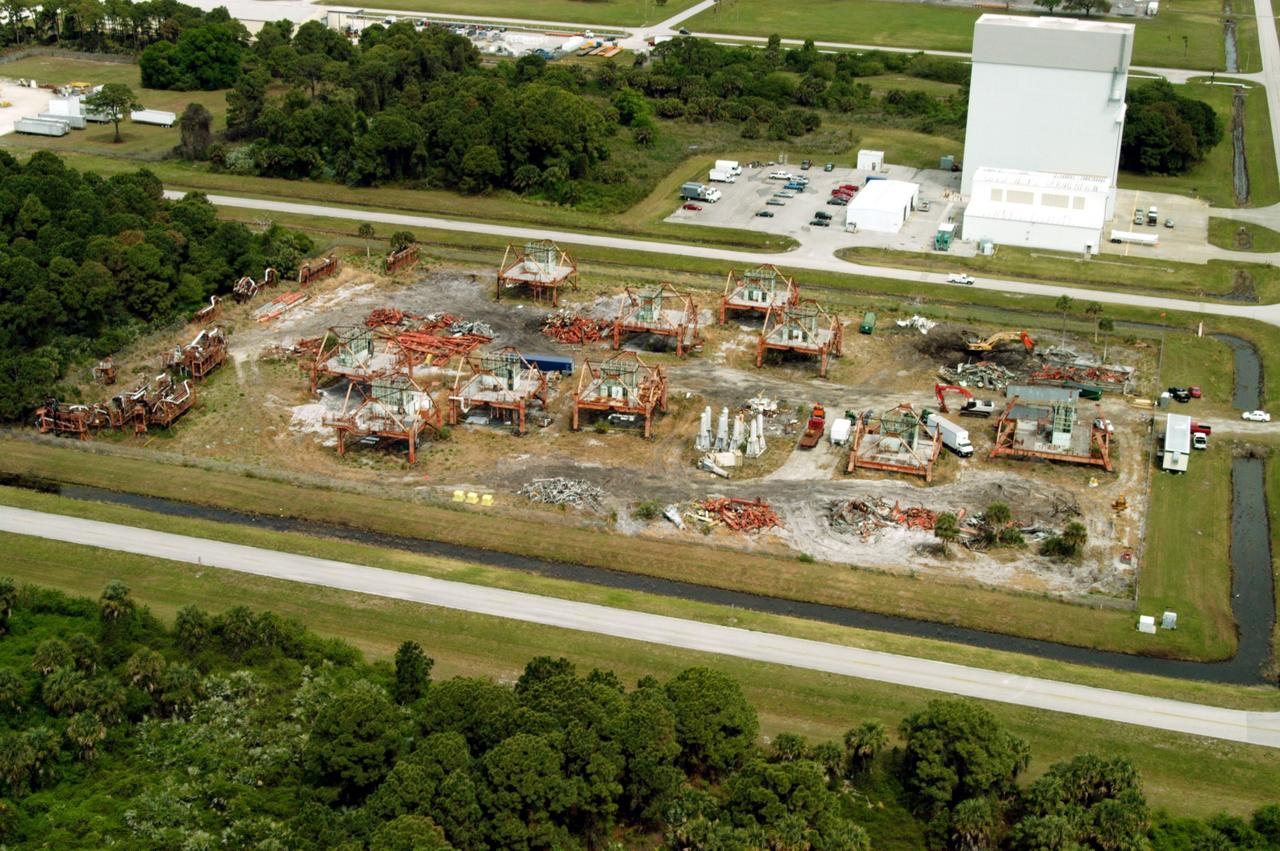 KENNEDY SPACE CENTER, FLA. -- This aerial photo shows the storage area containing Launch Umbilical Towers that were used during the early years of the Space Program. In the upper right corner of the storage field is a Caterpillar excavator with a 48-inch shear demolishing LUT-1, used to launch Apollo 8, Apollo 11, Skylab manned missions and the Apollo-Soyuz Test Project. The shear is one used in the deconstruction of the Twin Towers in New York City after 9/11.