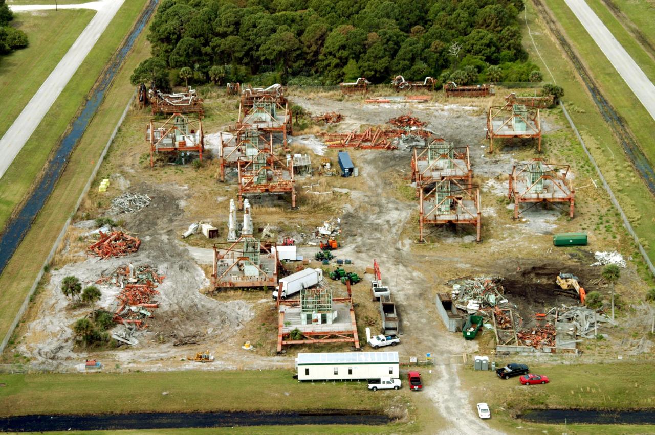KENNEDY SPACE CENTER, FLA. -- This aerial photo shows the storage area containing Launch Umbilical Towers that were used during the early years of the Space Program. In the lower right corner of the storage field is a Caterpillar excavator with a 48-inch shear demolishing LUT-1, used to launch Apollo 8, Apollo 11, Skylab manned missions and the Apollo-Soyuz Test Project. The shear is one used in the deconstruction of the Twin Towers in New York City after 9/11.