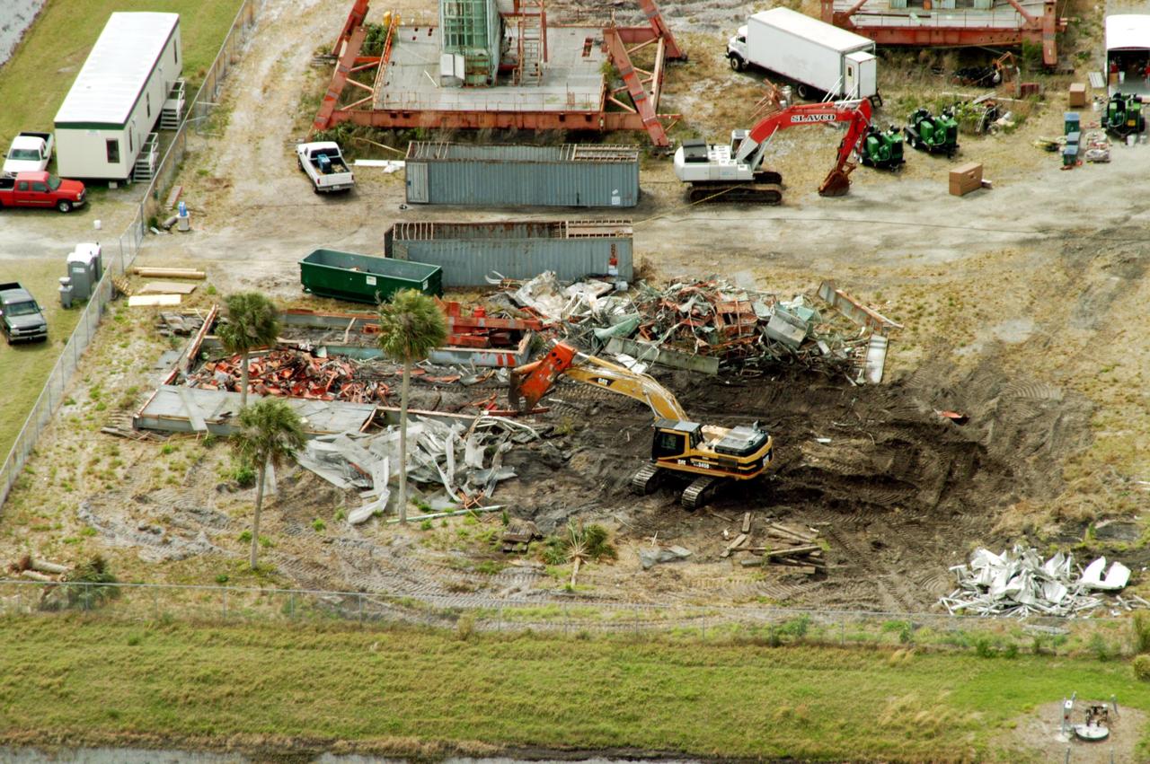 KENNEDY SPACE CENTER, FLA. -- This aerial photo shows the storage area containing Launch Umbilical Towers that were used during the early years of the Space Program. The central focus is a Caterpillar excavator with a 48-inch shear demolishing LUT-1, used to launch Apollo 8, Apollo 11, Skylab manned missions and the Apollo-Soyuz Test Project. The shear is one used in the deconstruction of the Twin Towers in New York City after 9/11.