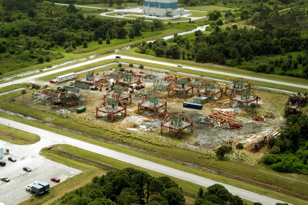 KENNEDY SPACE CENTER, FLA. -- This aerial photo shows the storage area containing Launch Umbilical Towers that were used during the early years of the Space Program. In the lower left corner of the storage field is a Caterpillar excavator with a 48-inch shear demolishing LUT-1, used to launch Apollo 8, Apollo 11, Skylab manned missions and the Apollo-Soyuz Test Project. The shear is one used in the deconstruction of the Twin Towers in New York City after 9/11.