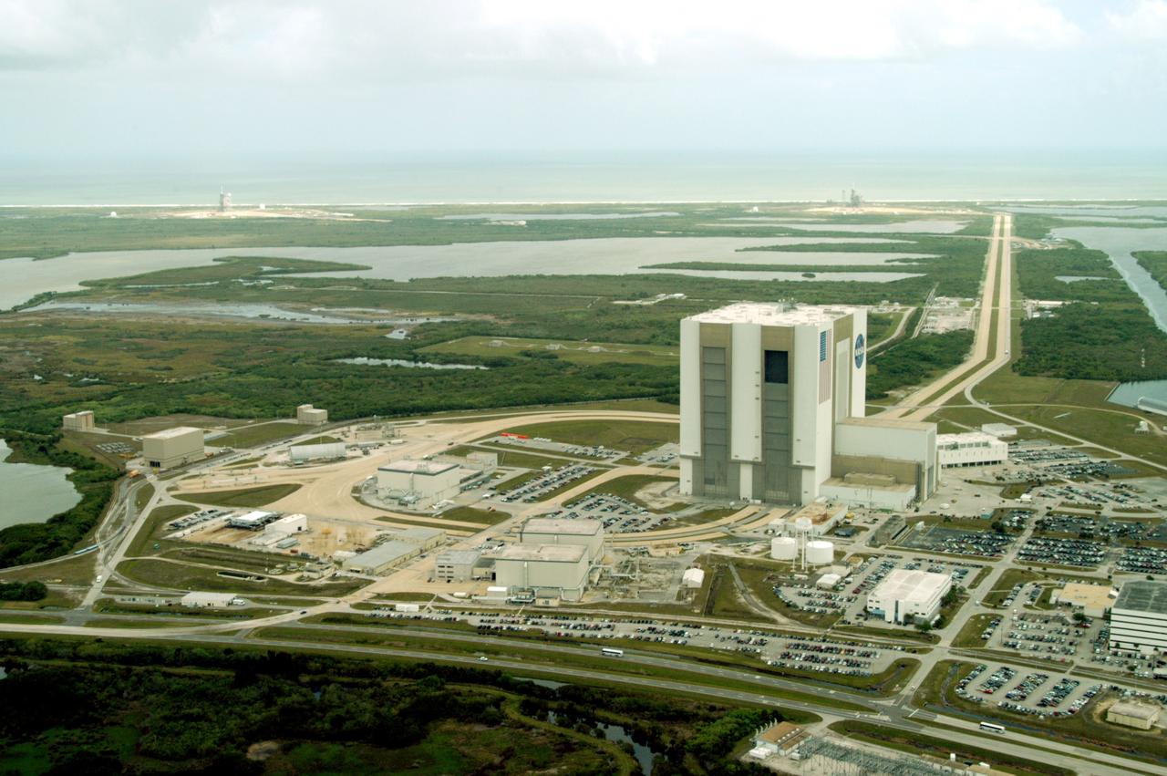 CAPE CANAVERAL, Fla. -- This aerial photo shows the expanse of the Launch Complex 39 Area, bordered at the top by the Atlantic and a cloud-filled sky. At center right, towering above  the surrounding sites, is the Vehicle Assembly Building. To the left is the Orbiter Processing Facility's Bay 3. In the foreground are OPF Bays 1 and 2. The two-lane crawlerway stretches from  the VAB toward the coast, site of Launch Pad 39A, closest, and Launch Pad 39B, far left. Between the VAB and the ocean sprawl the Banana Creek and the Banana River. Photo credit: NASA