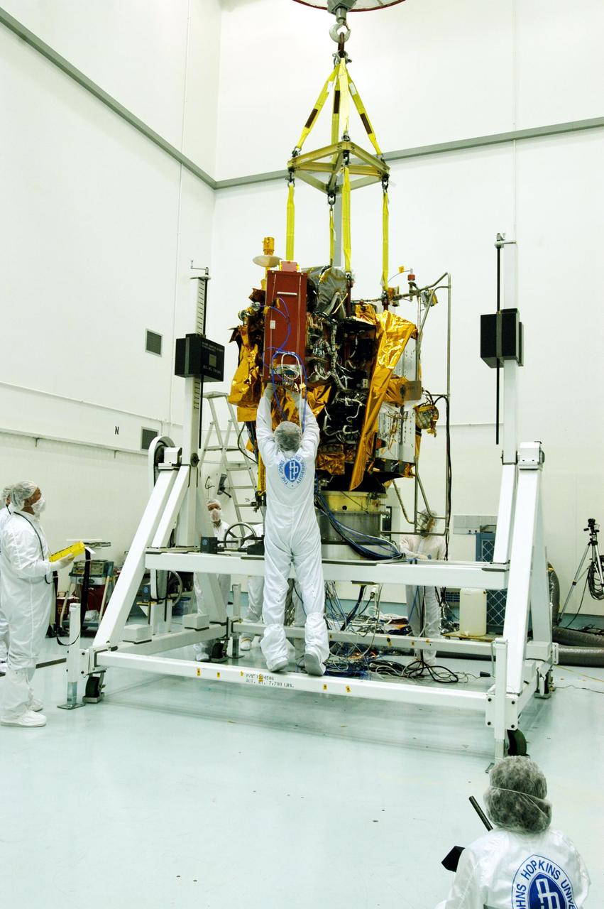 KENNEDY SPACE CENTER, FLA. -- At Astrotech Space Operations facilities near KSC, workers make adjustments to the Mercury Surface, Space Environment, Geochemistry and Ranging (MESSENGER) spacecraft now resting on the turnover fixture. Workers will perform the propulsion system phasing test - firing gas through the thrusters in order to verify that the right thrusters fire when expected - as part of prelaunch testing at the site. Launch is scheduled for May 11 from Pad 17-B, Cape Canaveral Air Force Station. The spacecraft will fly past Venus three times and Mercury twice before starting a year-long orbital study of Mercury in July 2009.