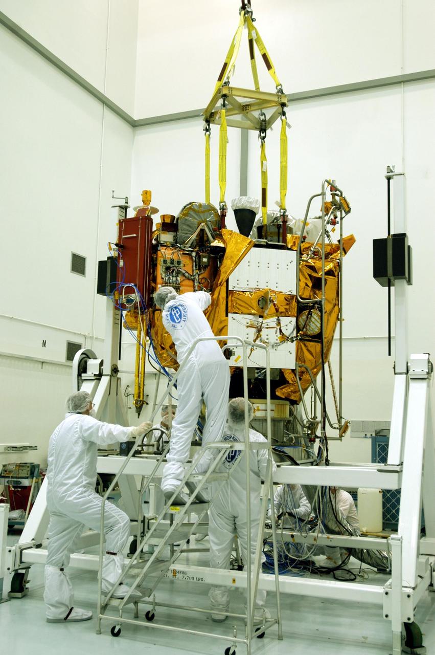 KENNEDY SPACE CENTER, FLA. -- Astrotech Space Operations facilities near KSC, workers remove protective covers from the Mercury Surface, Space Environment, Geochemistry and Ranging (MESSENGER) spacecraft now resting on the turnover fixture. Workers will perform the propulsion system phasing test - firing gas through the thrusters in order to verify that the right thrusters fire when expected - as part of prelaunch testing at the site. Launch is scheduled for May 11 from Pad 17-B, Cape Canaveral Air Force Station. The spacecraft will fly past Venus three times and Mercury twice before starting a year-long orbital study of Mercury in July 2009.