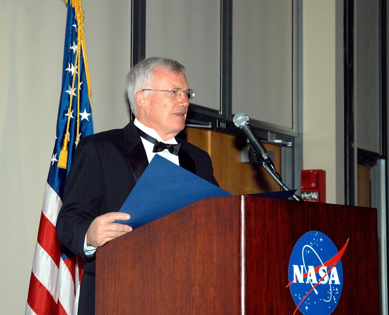 KENNEDY SPACE CENTER, FLA. -- At the annual National Space Club Debus Award Banquet held at the Dr. Kurt H. Debus Conference Facility in the Visitor Complex, David E. Bartine, chief technologist and associate director for the Spaceport Technology Development Office, reads a proclamation honoring John J. “Tip” Talone . The proclamation named April 3, 2004, in Knox County, Tenn., as John J. “Tip” Talone Jr. Day, in recognition of his being given the 2004 Debus Award. KSC’s Director of the International Space Station/Payloads Processing directorate, Talone was presented the award for his outstanding personal and professional efforts in supporting the U.S. space program, especially in his current role. The award was created by the National Space Club Florida Committee to recognize significant achievements and contributions made in Florida to American aerospace efforts. It is named for Dr. Kurt H. Debus, first director of KSC, from 1962 to 1974.