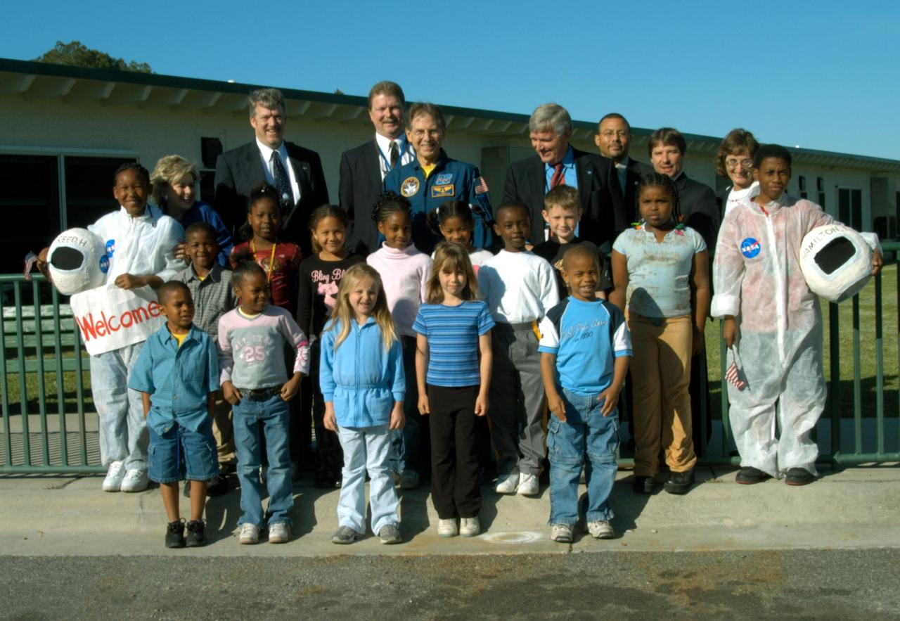 KENNEDY SPACE CENTER, FLA. -- Students at Oscar Patterson Elementary Magnet School in Panama City, Fla., gather for a photo with NASA representatives standing behind them.  At center is astronaut Sam Durrance; on the right is Center Director Jim Kennedy; behind Durrance at left is John Halsema, chief in the Government Relations Office.  Behind and right of Kennedy is Steve Lewis, his assistant.  Behind the student on the far right is Pam Biegert, chief of KSC’s Education Programs and University Research Office.  Kennedy is visiting NASA Explorer Schools in Florida and Georgia to share America’s new vision for space exploration with the next generation of explorers. Kennedy is talking with students about our destiny as explorers, NASA’s stepping stone approach to exploring Earth, the Moon, Mars and beyond, how space impacts our lives, and how people and machines rely on each other in space.