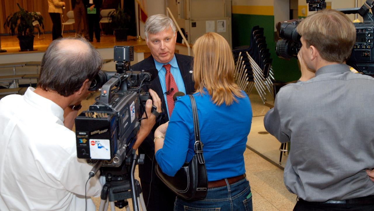 KENNEDY SPACE CENTER, FLA. -- Center Director Jim Kennedy (center) is interviewed by a reporter from channel 7 ABC-TV after his visit to Oscar Patterson Elementary Magnet School in Panama City, Fla.  He other NASA officials visited the school to share America’s new vision  for space exploration with the next generation of explorers. Kennedy is talking with students at NASA Explorer Schools in Florida and Georgia about our destiny as explorers, NASA’s stepping stone approach to exploring Earth, the Moon, Mars and beyond, how space impacts our lives, and how people and machines rely on each other in space.