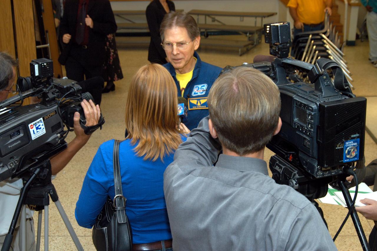 KENNEDY SPACE CENTER, FLA. -- Astronaut Sam Durrance (center) is interviewed by a reporter from channel 7 ABC-TV after his visit to Oscar Patterson Elementary Magnet School in Panama City, Fla.  He, Center Director Jim Kennedy and other NASA officials visited the school to share America’s new vision  for space exploration with the next generation of explorers. Kennedy is talking with students at NASA Explorer Schools in Florida and Georgia about our destiny as explorers, NASA’s stepping stone approach to exploring Earth, the Moon, Mars and beyond, how space impacts our lives, and how people and machines rely on each other in space.
