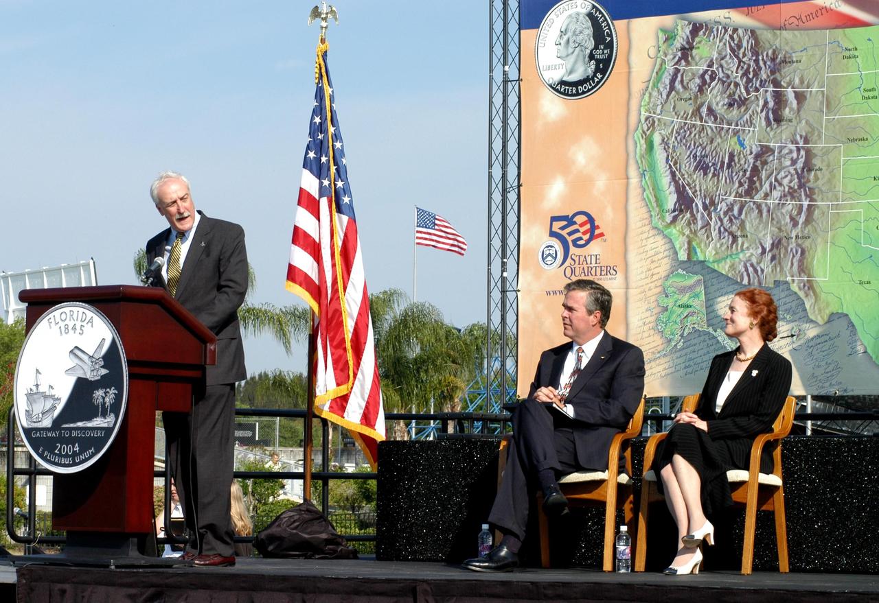 KENNEDY SPACE CENTER, FLA. -- NASA Administrator Sean O’Keefe comments on the design of the new Florida quarter during the ceremony at the KSC Visitor Complex that launched the coin.  Sharing the stage with him are Florida Gov. Jeb Bush and U.S. Mint Director Henrietta Holsman Fore.  Also participating were Center Director Jim Kennedy, who emceed, and Deputy Secretary of the Treasury Samuel W. Bodman.  The quarter celebrates Florida as a destination for explorers in the past, a launch site for future explorers into space and an inviting place for visitors today.