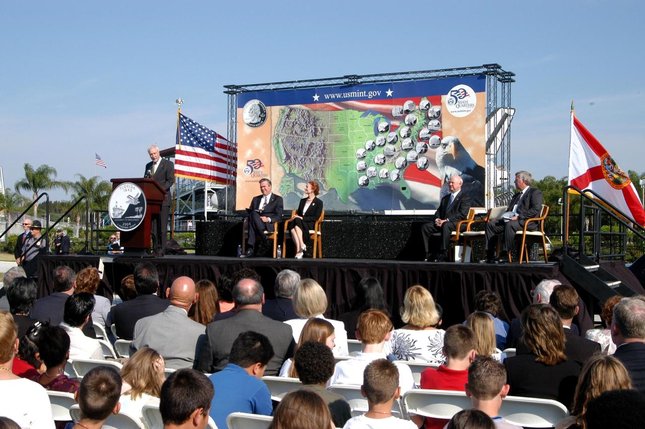 KENNEDY SPACE CENTER, FLA. -- NASA Administrator Sean O’Keefe comments on the design of the new Florida quarter during the ceremony at the KSC Visitor Complex that launched the coin.  Sharing the stage with him are Florida Gov. Jeb Bush, U.S. Mint Director Henrietta Holsman Fore, Deputy Secretary of the Treasury Samuel W. Bodman and Center Director Jim Kennedy, who emceed.  The quarter celebrates Florida as a destination for explorers in the past, a launch site for future explorers into space and an inviting place for visitors today.