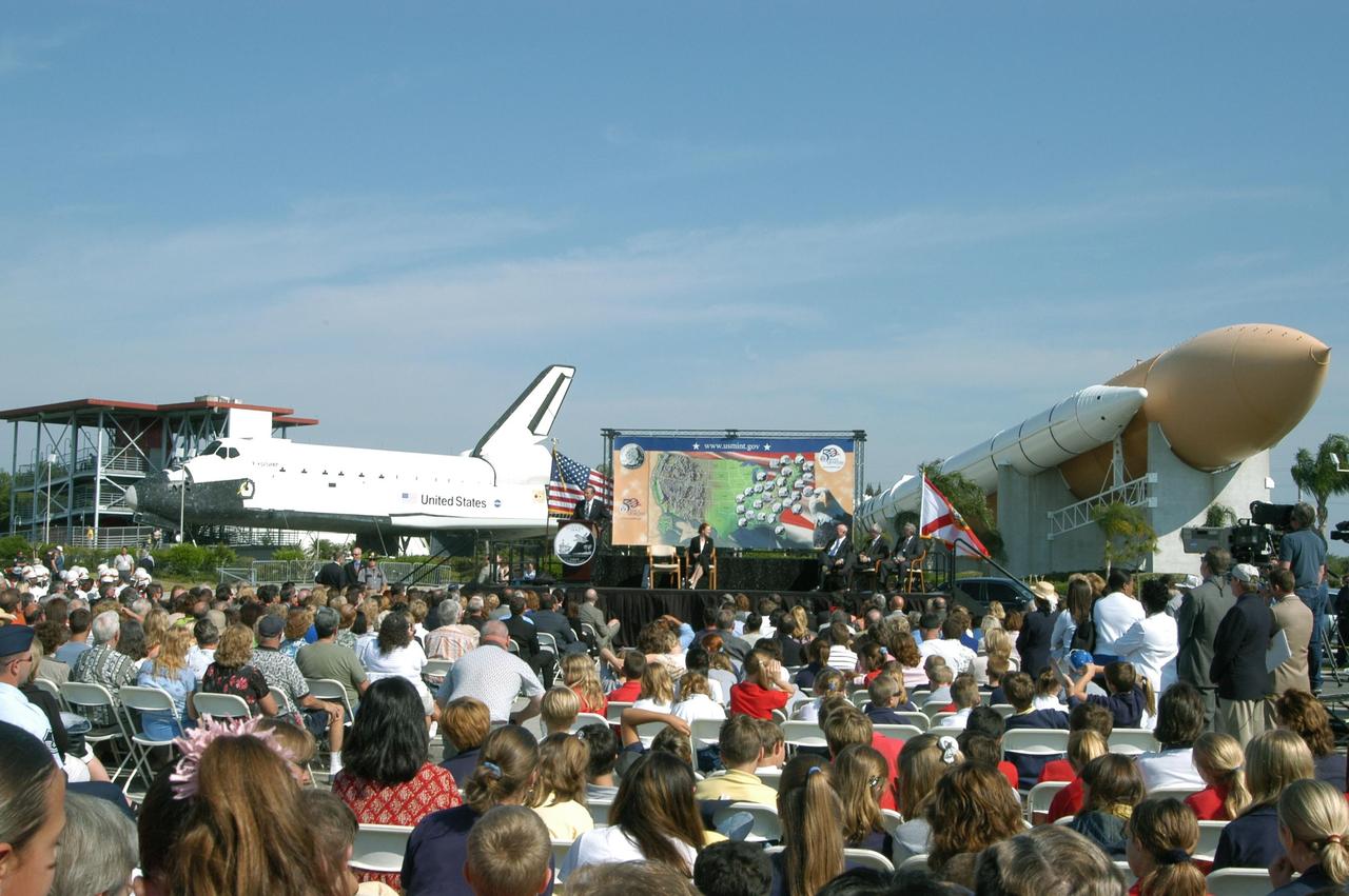 KENNEDY SPACE CENTER, FLA. -- A large crowd attends the launching ceremony for the new Florida quarter, held at the KSC Visitor Complex. Emceed by Center Director Jim Kennedy, the event included comments by NASA Administrator Sean O’Keefe and Deputy Secretary of the Treasury Samuel W. Bodman. The coin was also officially presented by U.S. Mint Director Henrietta Holsman Fore to Florida Gov. Jeb Bush. On the stage, a map of the United States, illustrating the state quarters issued to date, is framed between the orbiter mockup and SRB-external tank exhibit. The quarter celebrates Florida as the gateway to discovery -- a destination for explorers in the past, a launch site for space explorers of the future, and an inviting place for visitors today.