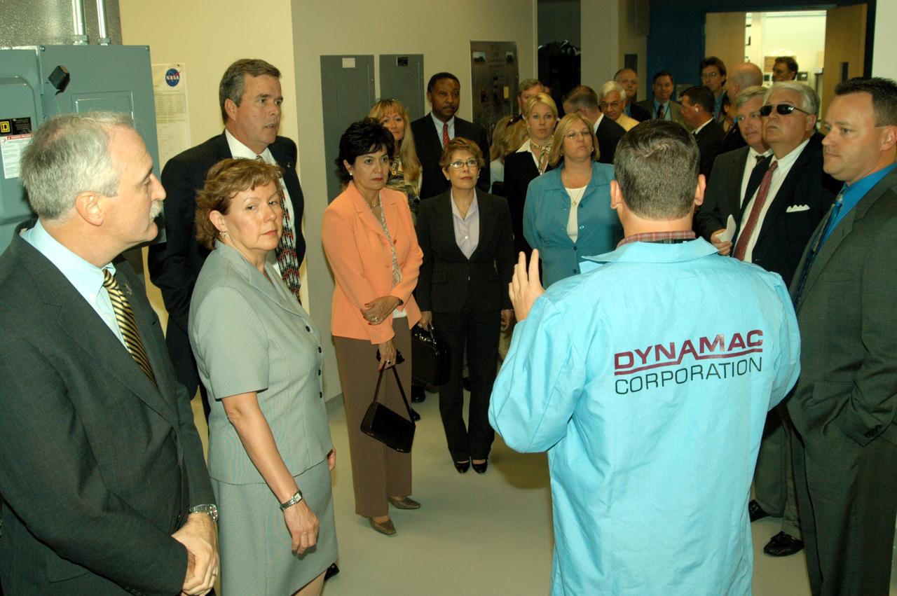 KENNEDY SPACE CENTER, FLA. -- Neil Yorio, a Dynamac scientist (right), explains the function of the KSC Space Life Sciences (SLS) Lab to a prestigious tour group. From left are NASA Administrator Sean O’Keefe and his wife, Laura; Florida Gov. Jeb Bush; Bernadette Kennedy, wife of the Center Director (CD); Columba Bush, wife of the governor; behind Mrs. Bush, former astronaut Winston Scott; and third from right, CD Jim Kennedy. The new lab is a state-of-the-art facility built for ISS biotechnology research. It was developed as a partnership between NASA-KSC and the State of Florida. The tour followed the launching ceremony at the KSC Visitor Complex for the new Florida quarter issued by the U.S. Mint. The ceremony was emceed by Kennedy and included remarks by O’Keefe, Bush, U.S. Mint Director Henrietta Holsman Fore and Deputy Secretary of the Treasury Samuel W. Bodman.