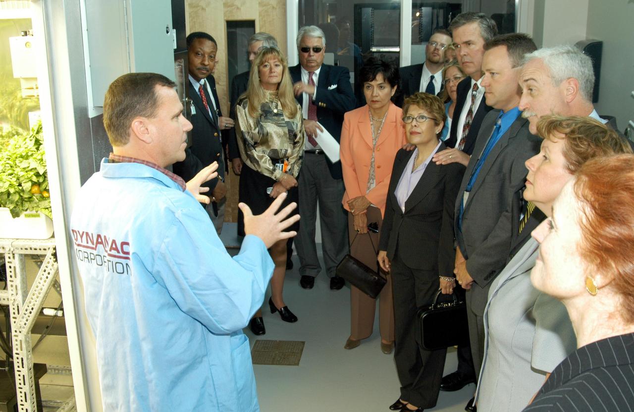 KENNEDY SPACE CENTER, FLA. -- Neil Yorio, a Dynamac scientist(left), explains the function of the KSC Space Life Sciences (SLS) Lab to a prestigious tour group. In the background at left is former astronaut Winston Scott; at center is Bernadette Kennedy, wife of the Center Director (CD); next to her are Columba and Florida Gov. Jeb Bush; third from right is NASA Administrator Sean O’Keefe, next to his wife, Laura; and on the far right is U.S. Mint Director Henrietta Holsman Fore. The new lab is a state-of-the-art facility built for ISS biotechnology research. It was developed as a partnership between NASA-KSC and the State of Florida. The tour followed the launching ceremony at the KSC Visitor Complex for the new Florida quarter issued by the U.S. Mint. The ceremony was emceed by CD Jim Kennedy and included remarks by O’Keefe, Bush, Fore and Deputy Secretary of the Treasury Samuel W. Bodman.