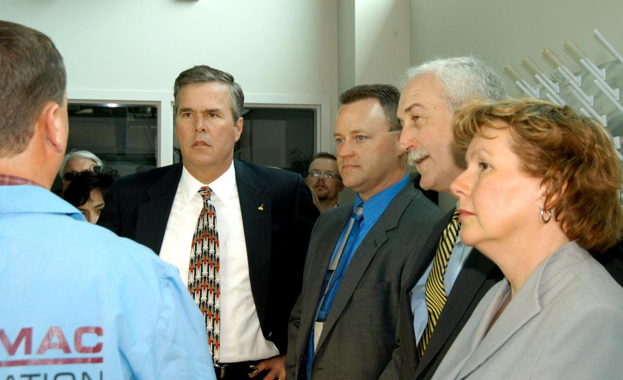 KENNEDY SPACE CENTER, FLA. -- Neil Yorio, a Dynamac scientist(left), explains the function of the KSC Space Life Sciences (SLS) Lab to a prestigious tour group: Florida Gov. Jeb Bush, left of center, and NASA Administrator Sean O’Keefe, and his wife, Laura, at right. Others in the group included former astronaut Winston Scott, U.S. Mint Director Henrietta Holsman Fore, and Center Director Jim Kennedy. The new lab is a state-of-the-art facility built for ISS biotechnology research. It was developed as a partnership between NASA-KSC and the State of Florida. The tour followed the launching ceremony at the KSC Visitor Complex for the new Florida quarter issued by the U.S. Mint. The ceremony was emceed by Kennedy and included remarks by O’Keefe, Bush, Fore and Deputy Secretary of the Treasury Samuel W. Bodman.