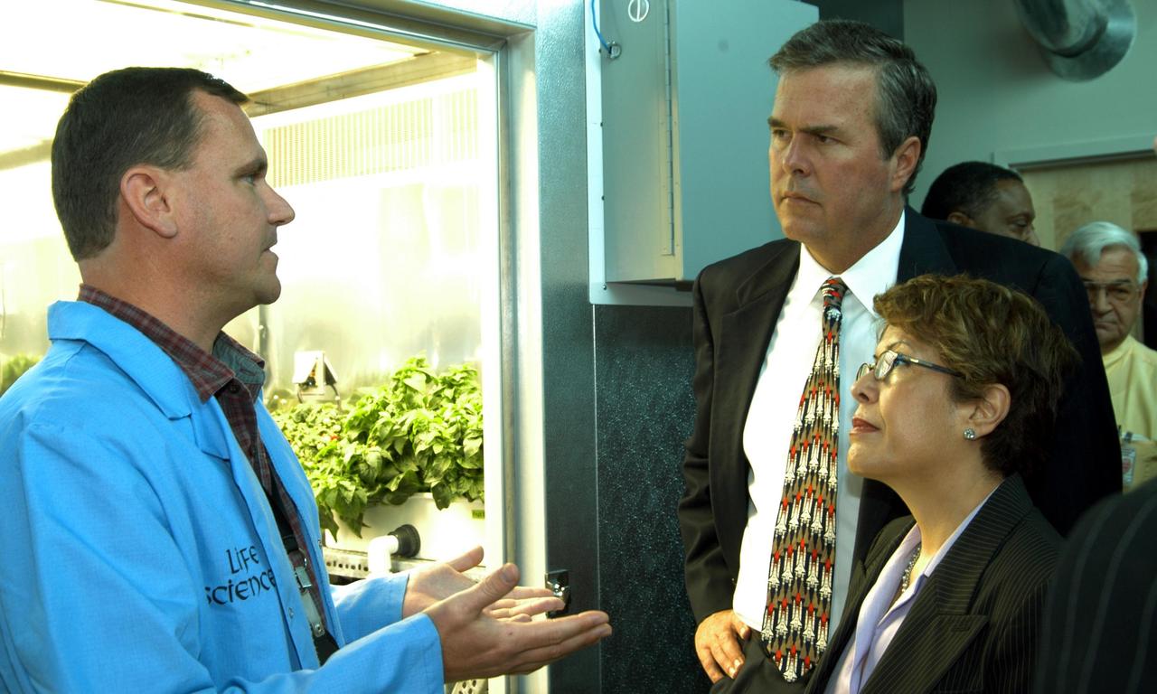 KENNEDY SPACE CENTER, FLA. -- Neil Yorio, a Dynamac scientist (left) in the KSC Space Life Sciences (SLS) Lab, explains the function of the facility to Florida Gov. Jeb Bush and his wife, Columba.  Bush and others were touring the Lab following the launching ceremony at the KSC Visitor Complex for the new Florida quarter issued by the U.S. Mint.  .  The new lab is a state-of-the-art facility built for ISS biotechnology research. It was developed as a partnership between NASA-KSC and the State of Florida. The launching ceremony was emceed by Center Director Jim Kennedy and included remarks by NASA Administrator Sean O’Keefe, Bush, U.S. Mint Director Henrietta Holsman Fore and Deputy Secretary of the Treasury Samuel W. Bodman.