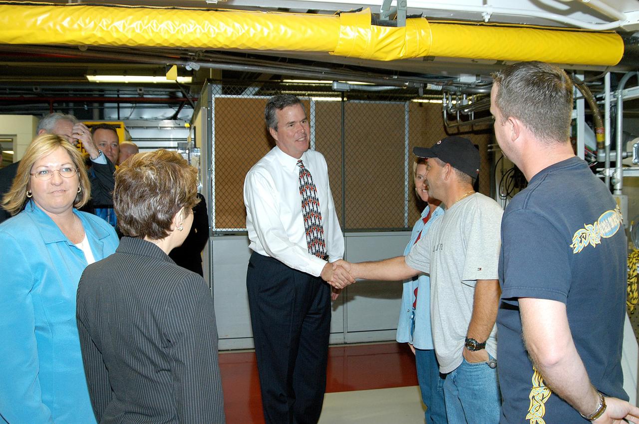 KENNEDY SPACE CENTER, FLA. -- On a tour of the Orbiter Processing Facility, Florida Gov. Jeb Bush (center) greets workers.  The tour followed the launching ceremony at the KSC Visitor Complex for the new Florida quarter issued by the U.S. Mint. The ceremony was emceed by Center Director Jim Kennedy and included remarks by NASA Administrator Sean O’Keefe, Bush, U.S. Mint Director Henrietta Holsman Fore and Deputy Secretary of the Treasury Samuel W. Bodman.