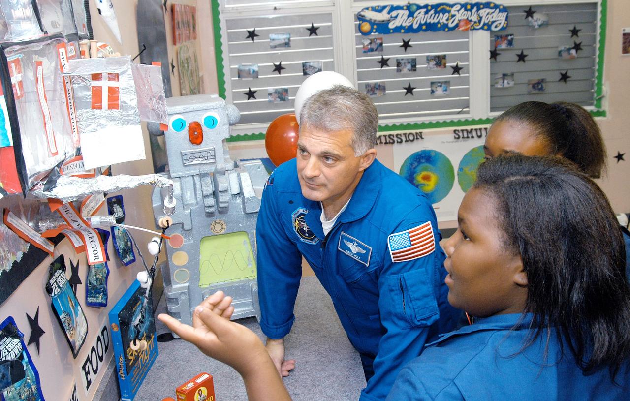 KENNEDY SPACE CENTER, FLA. - Astronaut Dr. David A. Wolf learns about a science project from students at Carol City Elementary School, a NASA Explorer School, in Miami, Fla. Wolf is accompanying Center Director Jim Kennedy on a visit to the school to share America’s new vision for space exploration with the next generation of explorers. Kennedy is talking with students about our destiny as explorers, NASA’s stepping stone approach to exploring Earth, the Moon, Mars and beyond, how space impacts our lives, and how people and machines rely on each other in space.