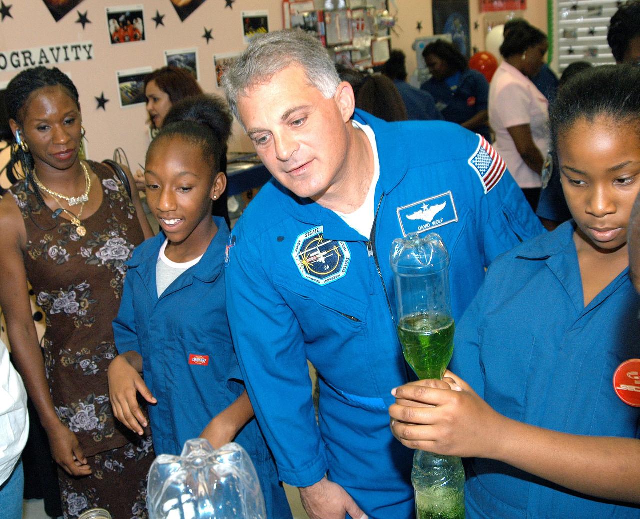 KENNEDY SPACE CENTER, FLA. - Astronaut Dr. David A. Wolf looks at students’ science project creating tornados during a visit to Carol City Elementary School, a NASA Explorer School, in Miami, Fla. Wolf is accompanying Center Director Jim Kennedy on a visit to the school to share America’s new vision for space exploration with the next generation of explorers. Kennedy is talking with students about our destiny as explorers, NASA’s stepping stone approach to exploring Earth, the Moon, Mars and beyond, how space impacts our lives, and how people and machines rely on each other in space.