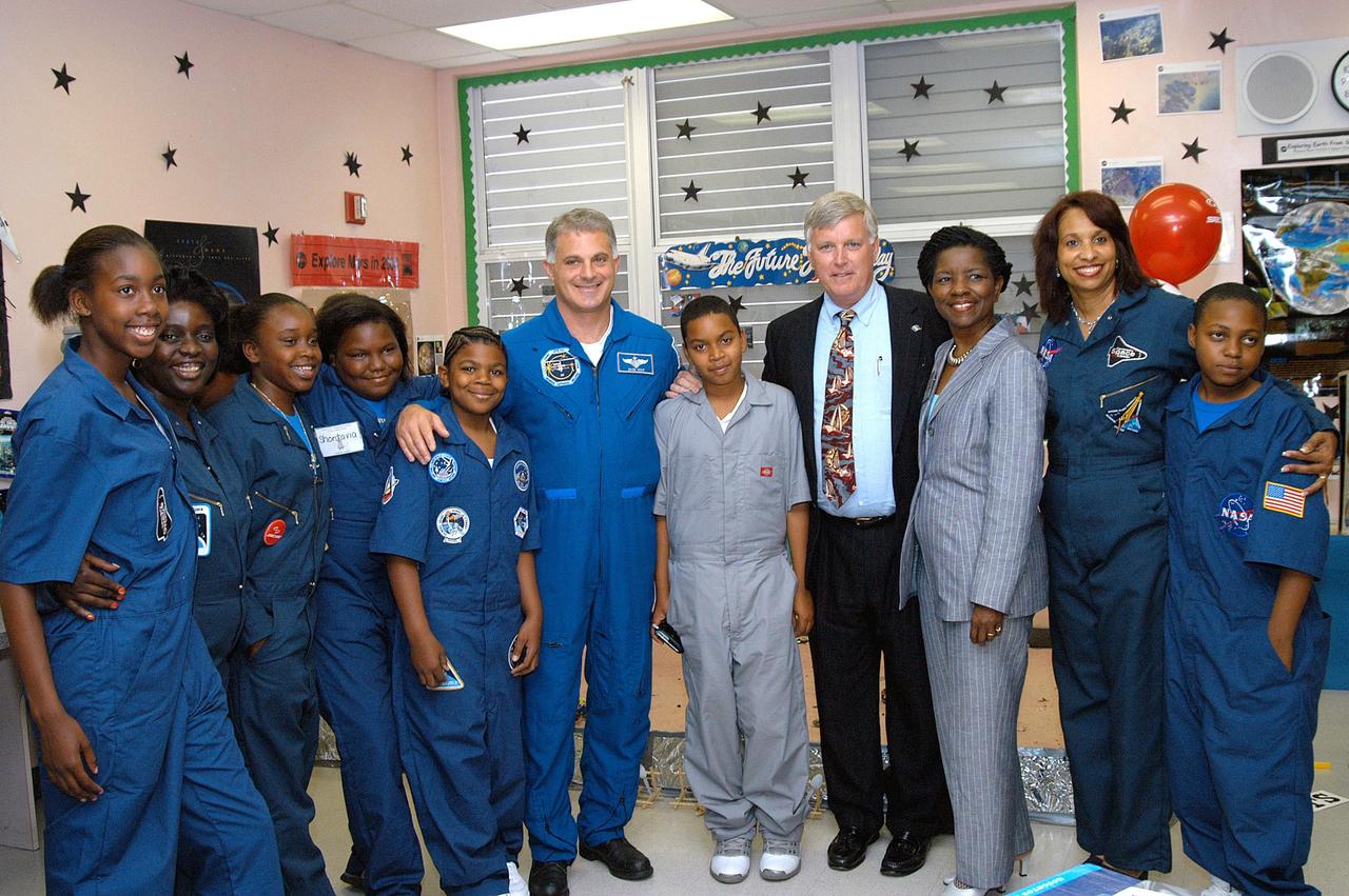 KENNEDY SPACE CENTER, FLA. - Astronaut Dr. David A. Wolf (sixth from left), Center Director Jim Kennedy (fourth from right) and Principal Claudia Hessing (second from right) pose with students during Kennedy and Wolf’s visit to Carol City Elementary School, a NASA Explorer School, in Miami, Fla. Kennedy is sharing America’s new vision for space exploration with the next generation of explorers. He and Wolf talked with students about our destiny as explorers, NASA’s stepping stone approach to exploring Earth, the Moon, Mars and beyond, how space impacts our lives, and how people and machines rely on each other in space.