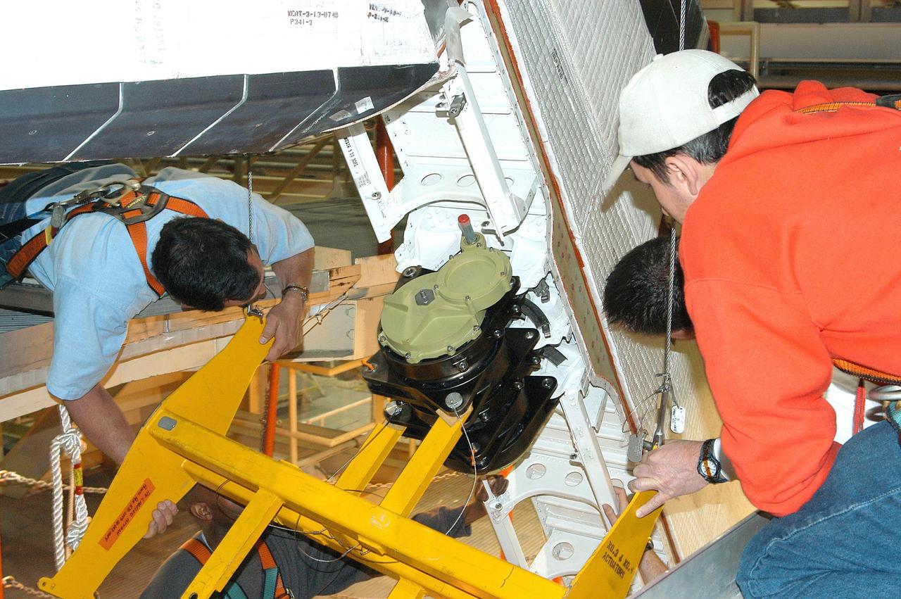 KENNEDY SPACE CENTER, FLA. -  United Space Alliance technicians verify the alignment of Rudder Speed Brake actuator No.4 as it is attached to Space Shuttle orbiter Discovery in the Orbiter Processing Facility. Discovery has been assigned to the first Return to Flight mission, STS-114, a logistics flight to the International Space Station.