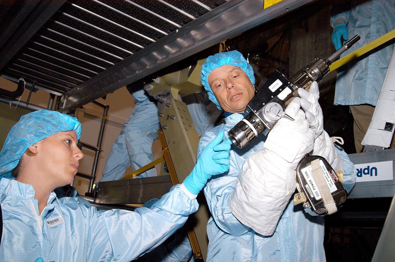 KENNEDY SPACE CENTER, FLA. - STS-116 Mission Specialist Christer Fuglesang (right) (European Space Agency) practices using a tool that is part of the equipment for the mission. He joined STS-118 crew members for the familiarization activities in the Space Station Processing Facility. The STS-116 mission will deliver the third port truss segment, the P5 Truss, to attach to the second port truss segment, the P3/P4 Truss. The STS-118 mission will be delivering and installing the third starboard truss segment, the ITS S5, to the International Space Station, and carry a SPACEHAB Single Cargo Module with supplies and equipment. Launch dates for both missions are under review.