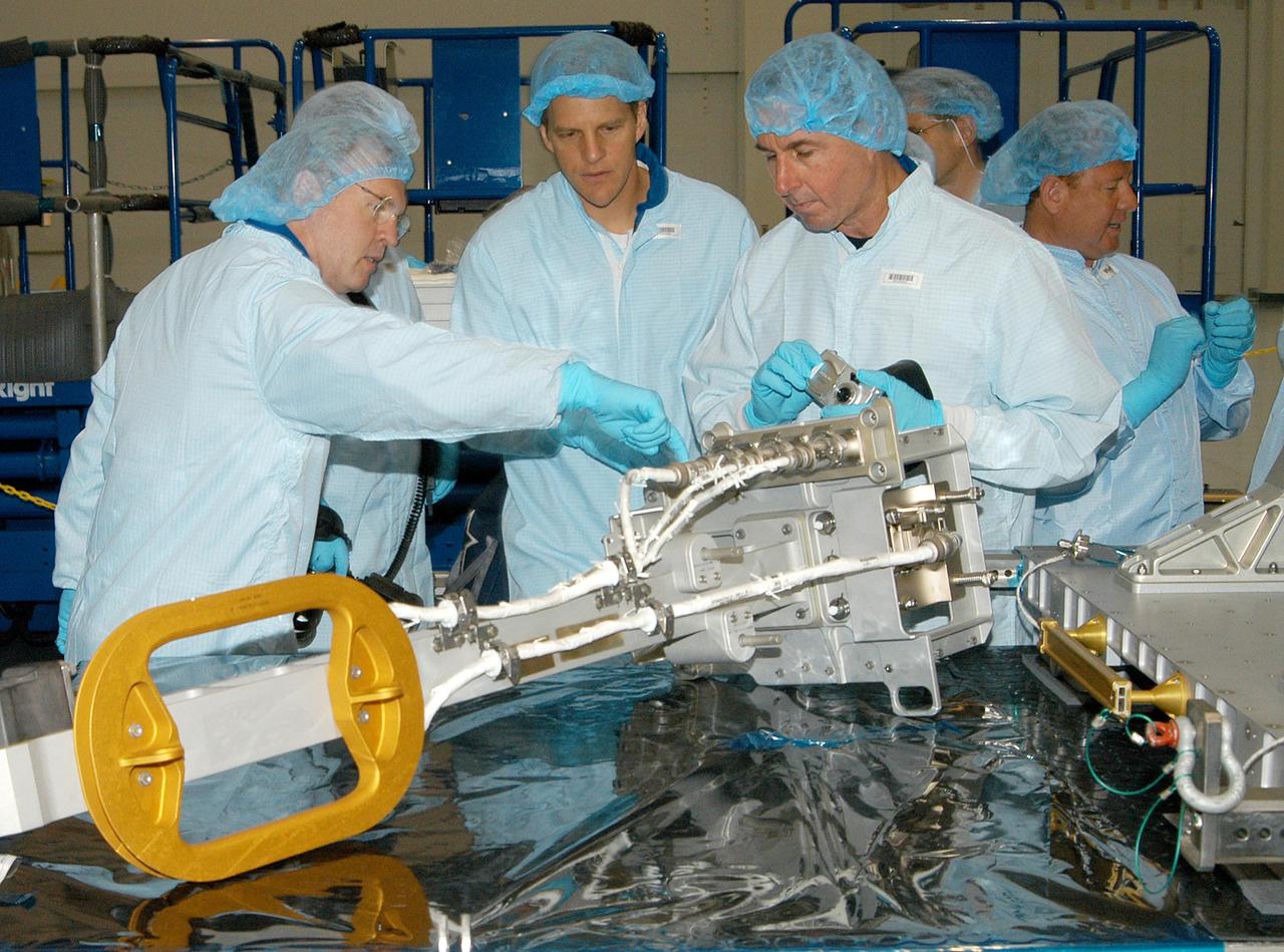 KENNEDY SPACE CENTER, FLA. - In the Space Station Processing Facility, members of several Space Shuttle mission crews get a close look at the Video Stanchion Support Assembly (VSSA) that will fly on STS-114 (Logistics Flight 1). From left are STS-114 Mission Specialist Andrew Thomas, STS-118 Mission Specialist Scott Parazynski and STS-114 Mission Specialist Stephen Robinson. At right is astronaut Barry Wilmore. The crews are at KSC for equipment familiarization.