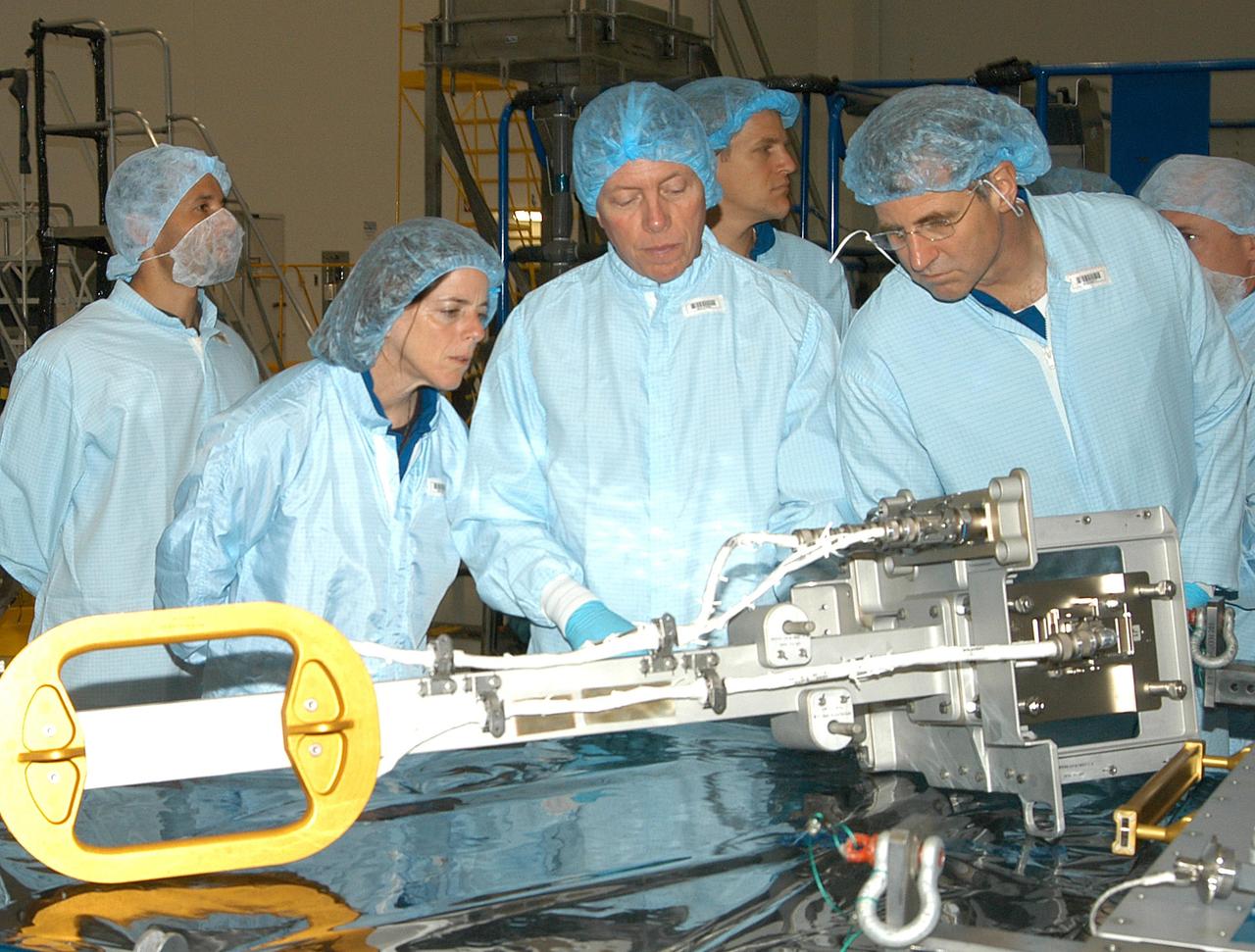 KENNEDY SPACE CENTER, FLA. - In the Space Station Processing Facility, members of several Space Shuttle mission crews get a close look at the Video Stanchion Support Assembly (VSSA) that will fly on STS-114 (Logistics Flight 1). From left are STS-118 Mission Specialist Barbara Morgan, STS-116 Mission Specialist Christer Fuglesang (European Space Agency), and STS-118 Mission Specialists Scott Parazynski and Dafydd Williams (Canadian Space Agency). The crews are at KSC for equipment familiarization.